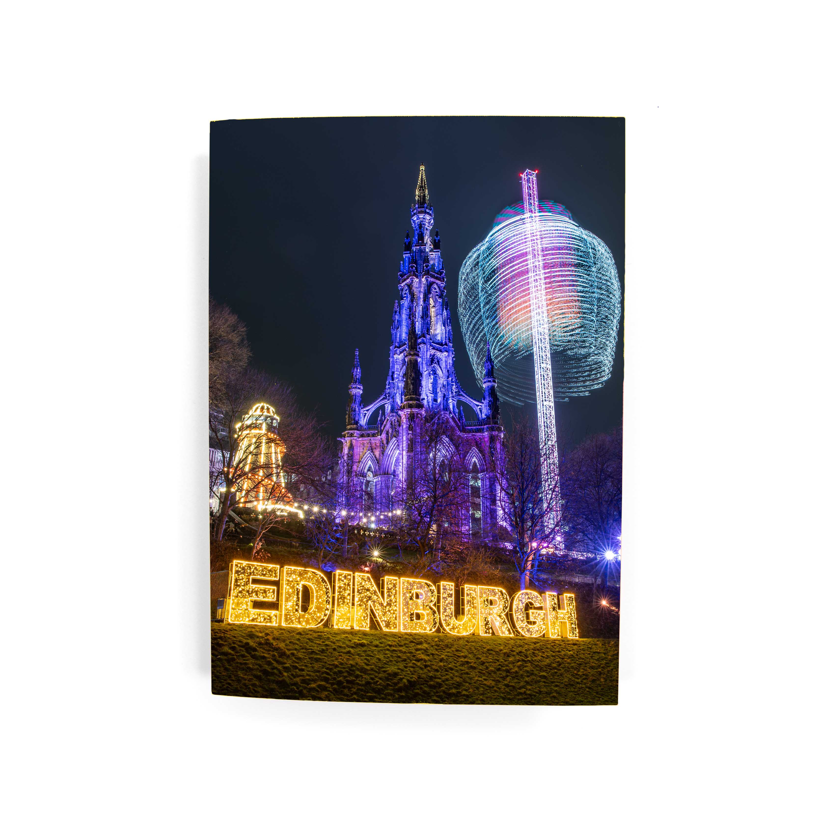 A greetings card with the Scot Monument lit up and a lit up Edinburgh sign in the Christmas Market.