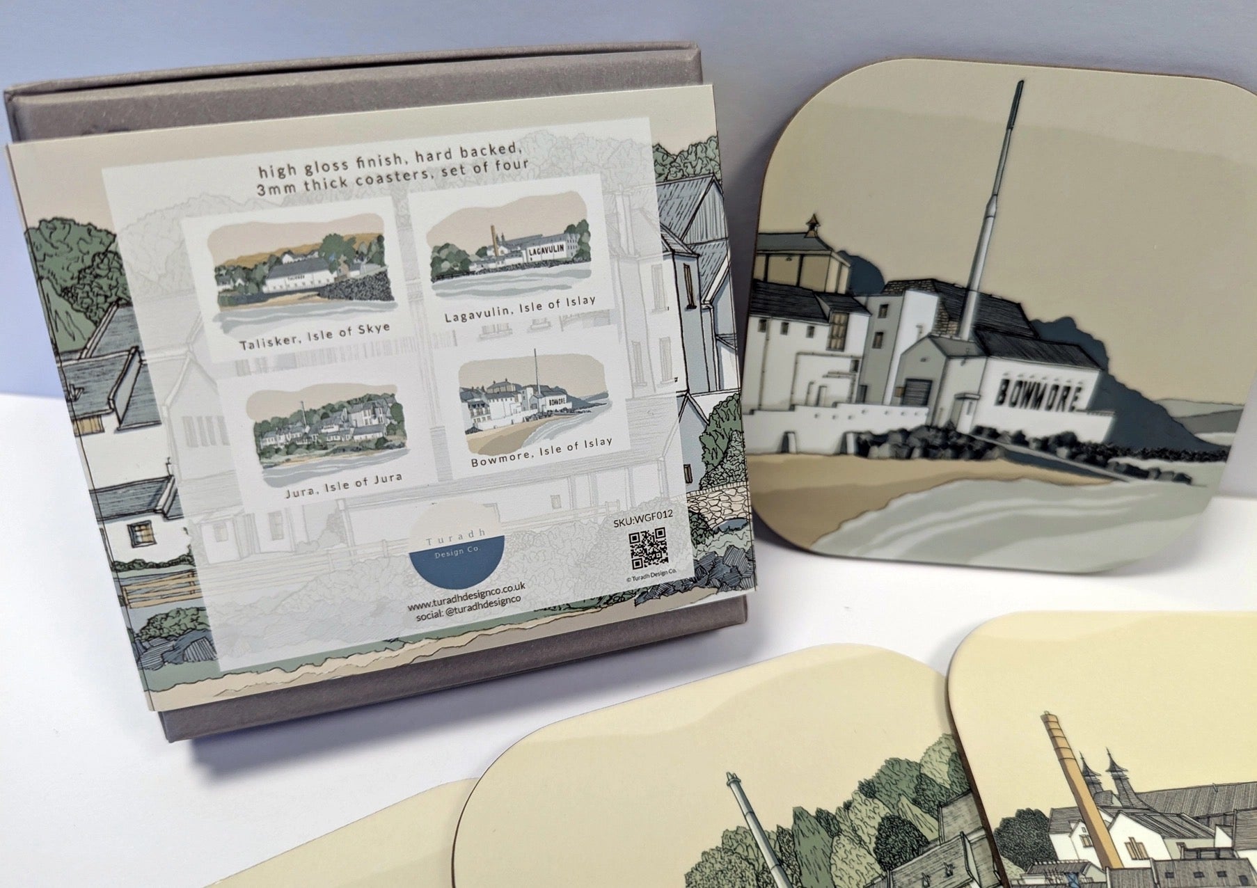 Set of coasters with scenic illustrations and a packaging box displaying the designs.