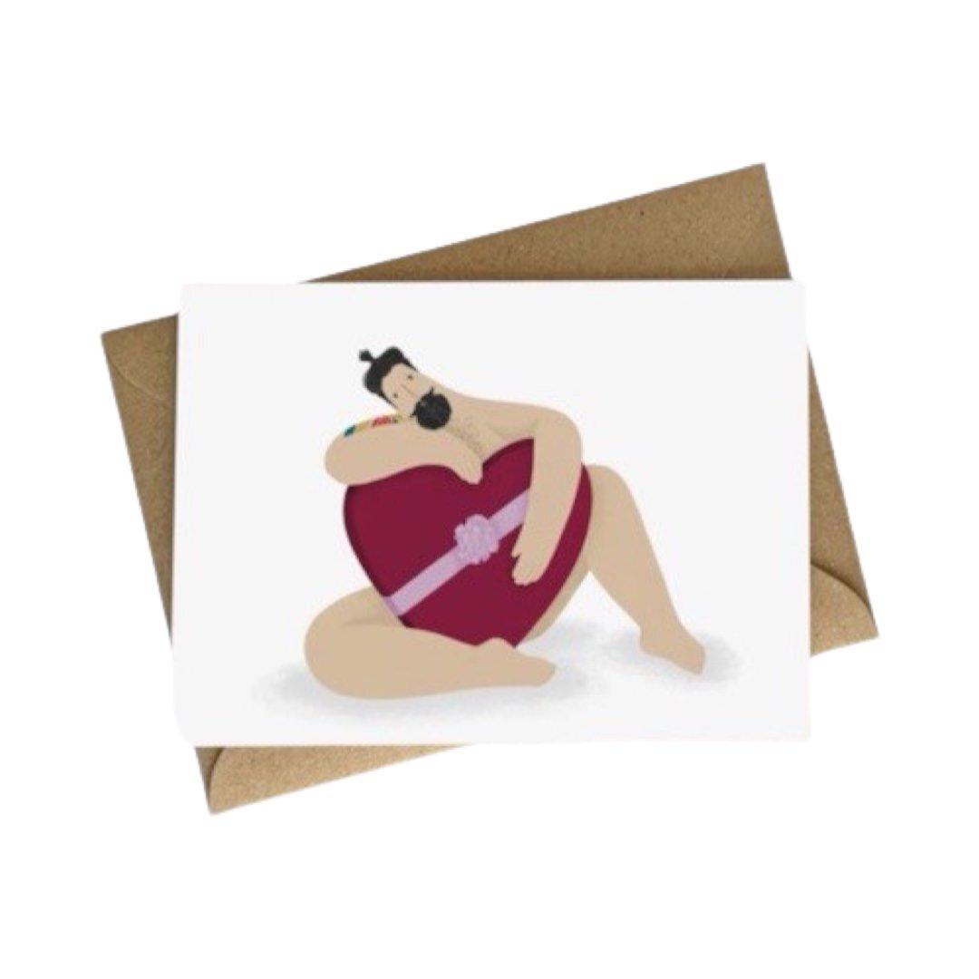 Love card featuring an illustration of a sexy, bearded, tattooed man in his leopard print swim trunks sitting holding a big red love heart.