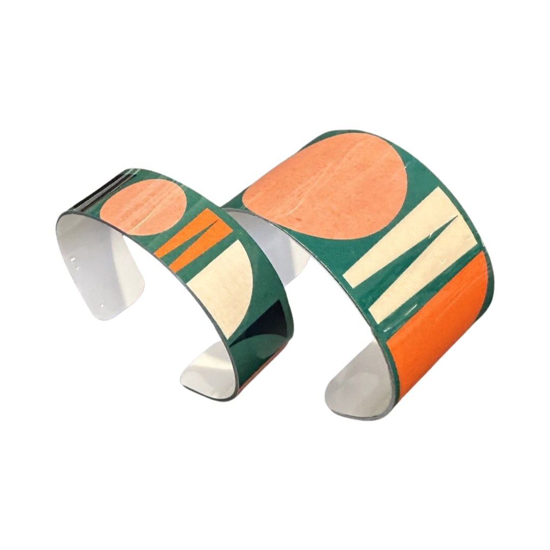 One wide and one narrow shapes cuff bracelets in green.