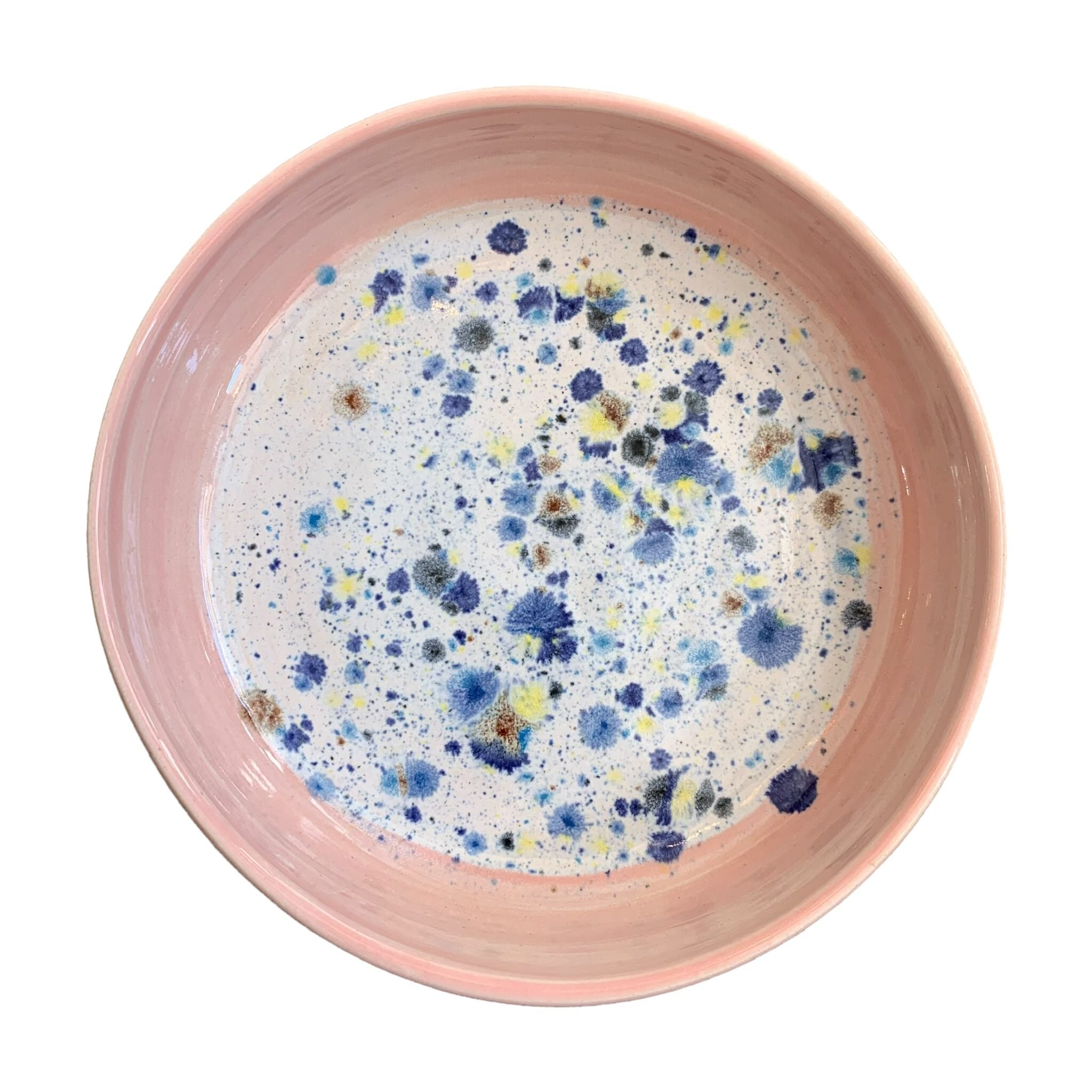 The top of a ceramic pasta bowl with a pink edge and a navy, yellow and white shoreline pattern in the centre.