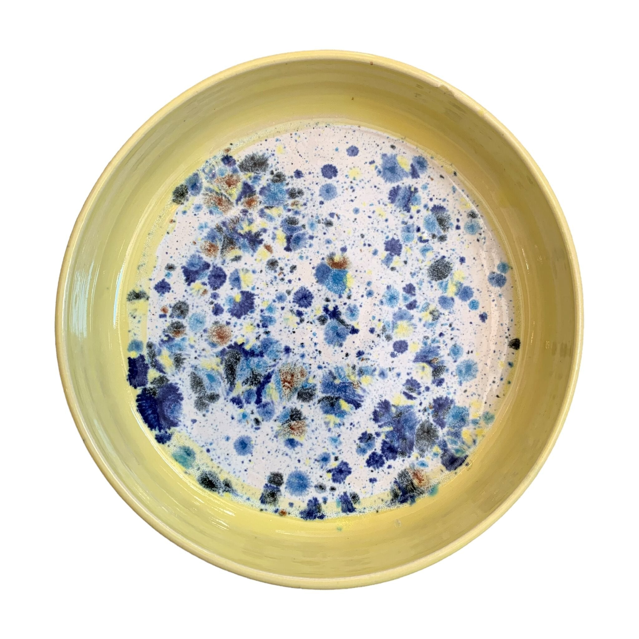 The top of a ceramic pasta bowl with a yellow edge and a navy, yellow and white shoreline pattern in the centre.