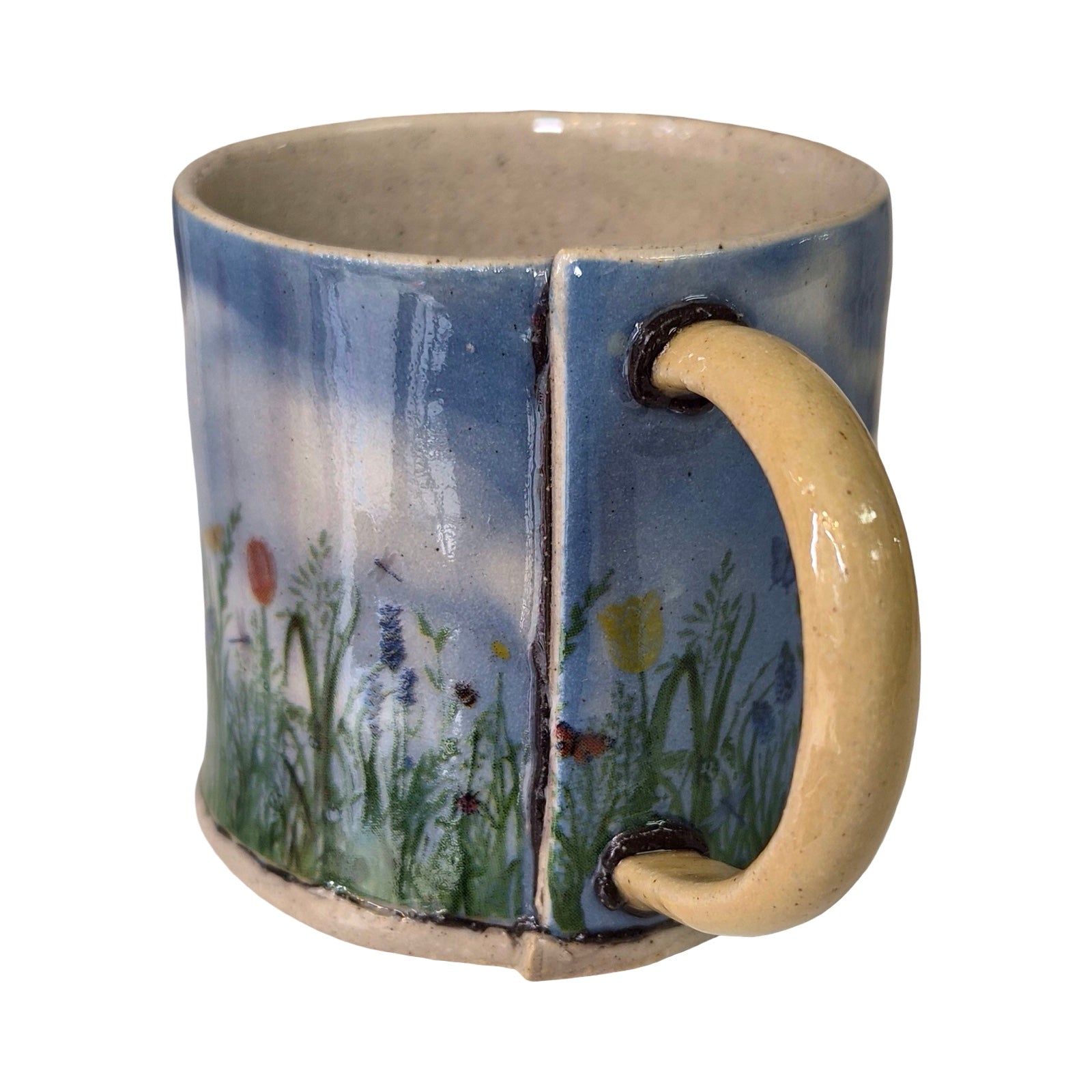 Ceramic mug with a handle, featuring a painted design of flowers and sky on a white background.