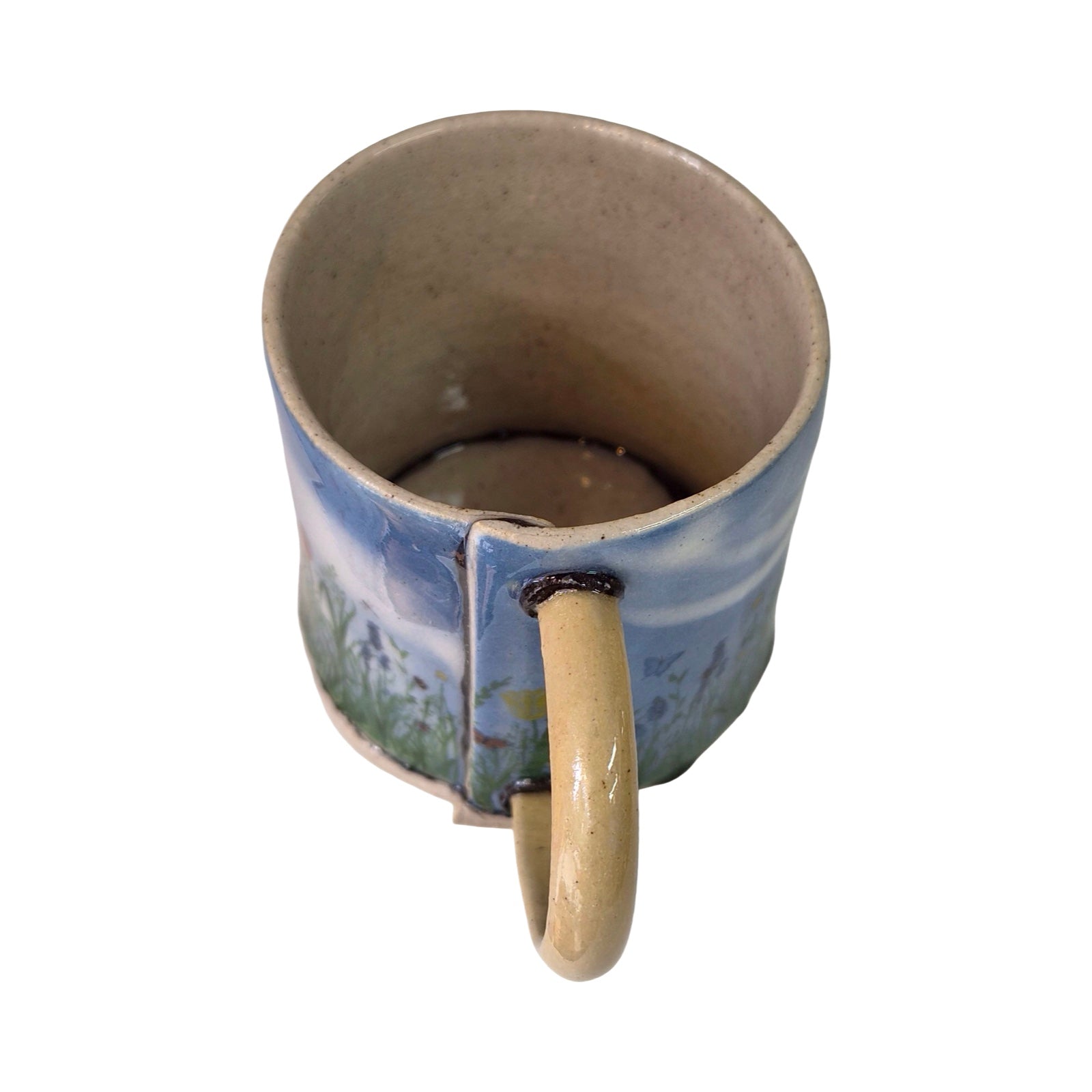 Ceramic mug with a scenic design on a white background.