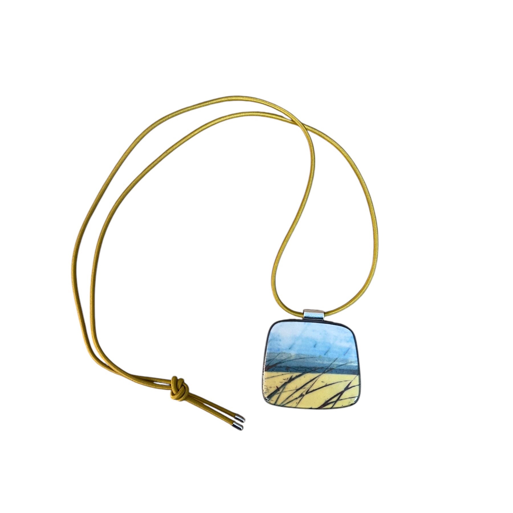 This pendent necklace is made from black porcelain casting slip layered with a white decorating slip and a ceramic decal, it is a wearable piece of art! The pendent has a yellow, blue and black abstract pattern, inspired by fields and coastlines