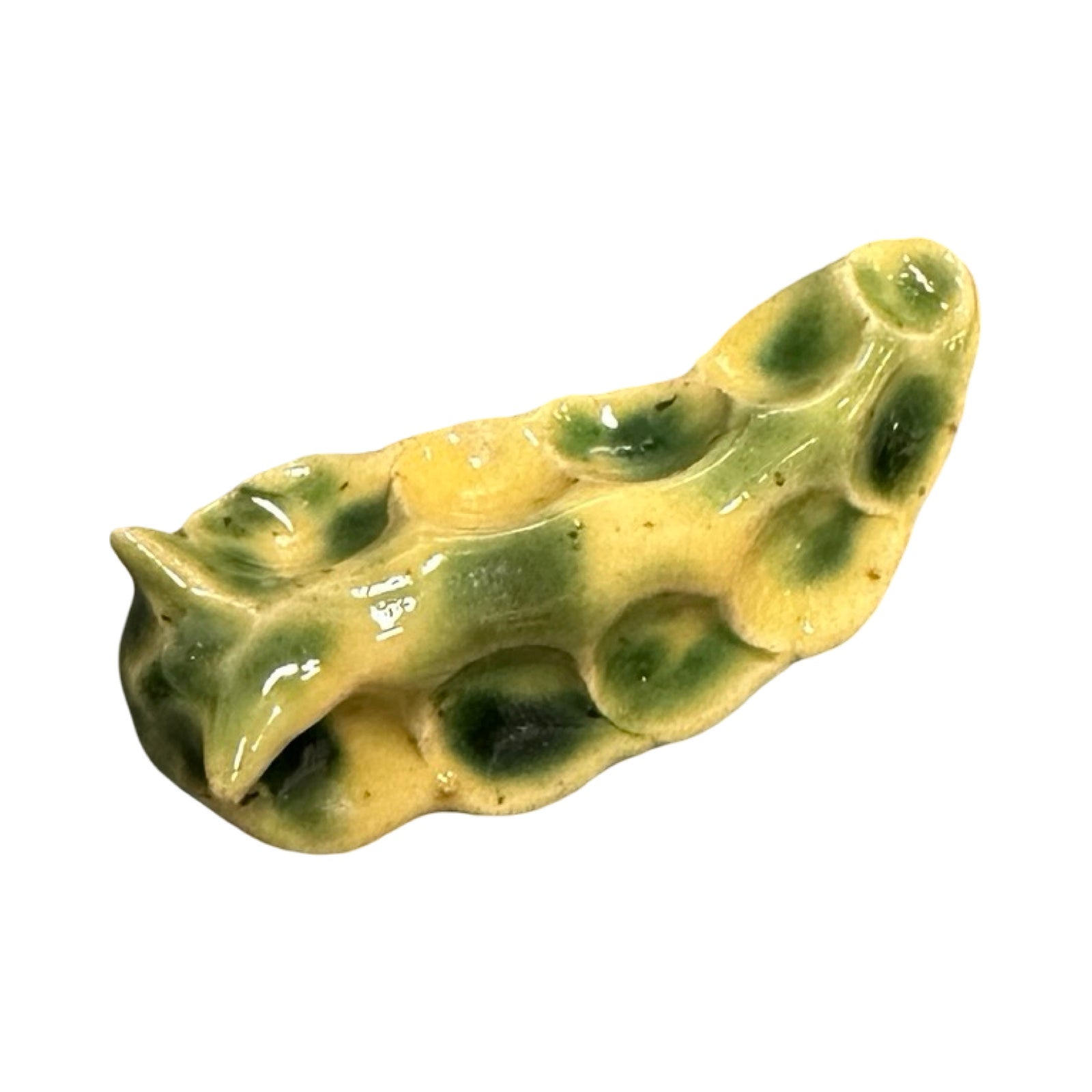 Green and yellow ceramic slug on a white background.