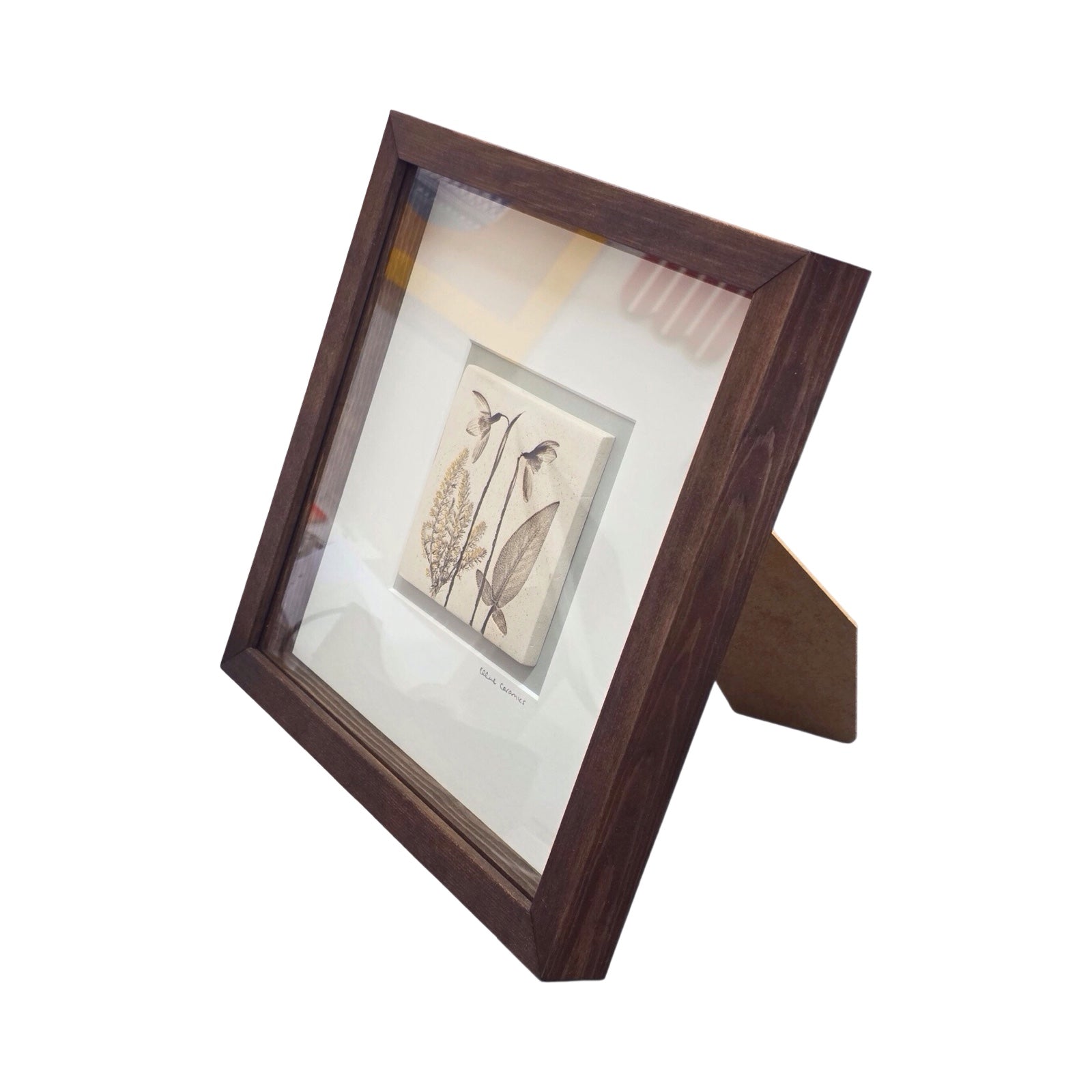 Framed botanical tile with a snowdrop in a wench wooden frame on a white background