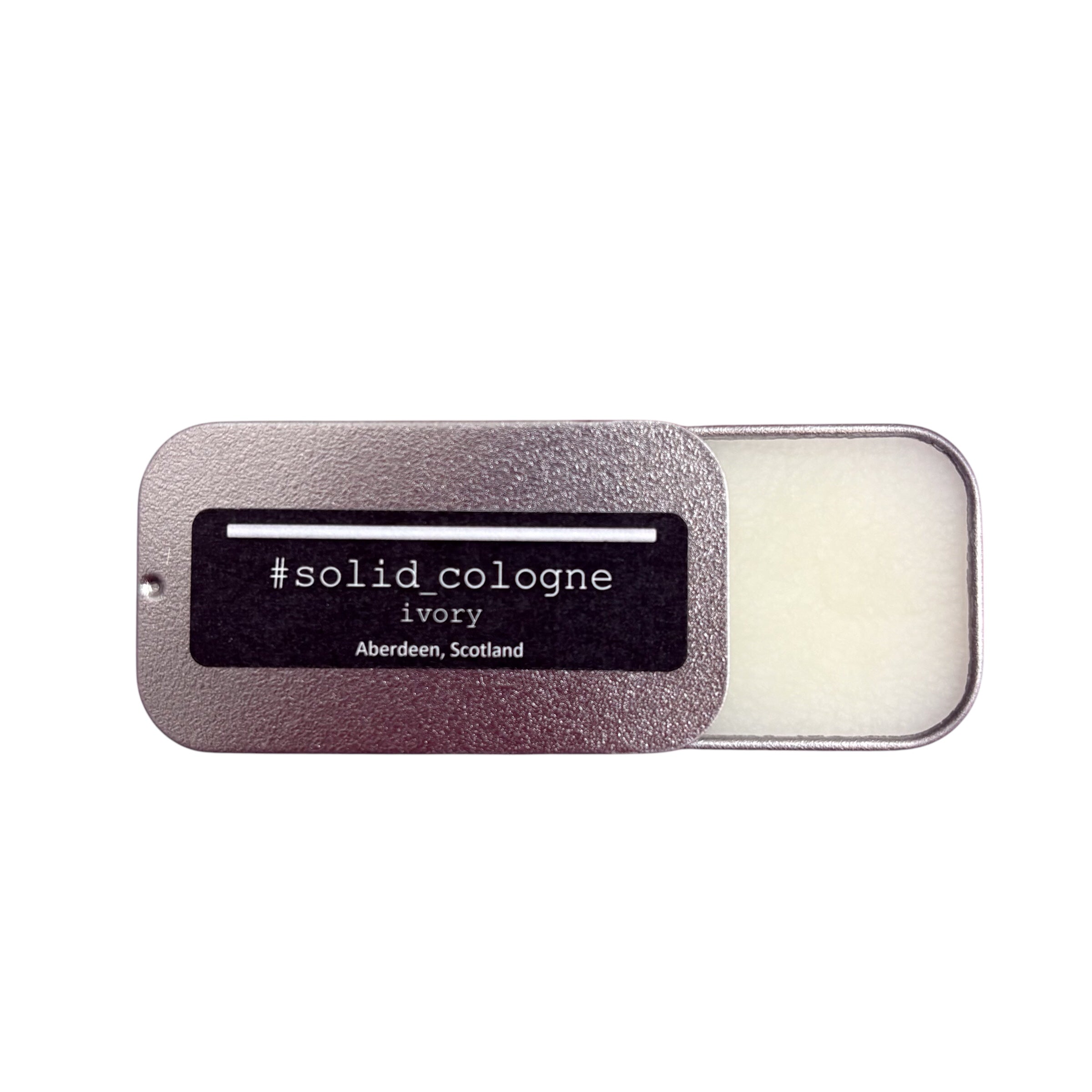 Small silver tin of "ivory' scented solid cologne, half open.