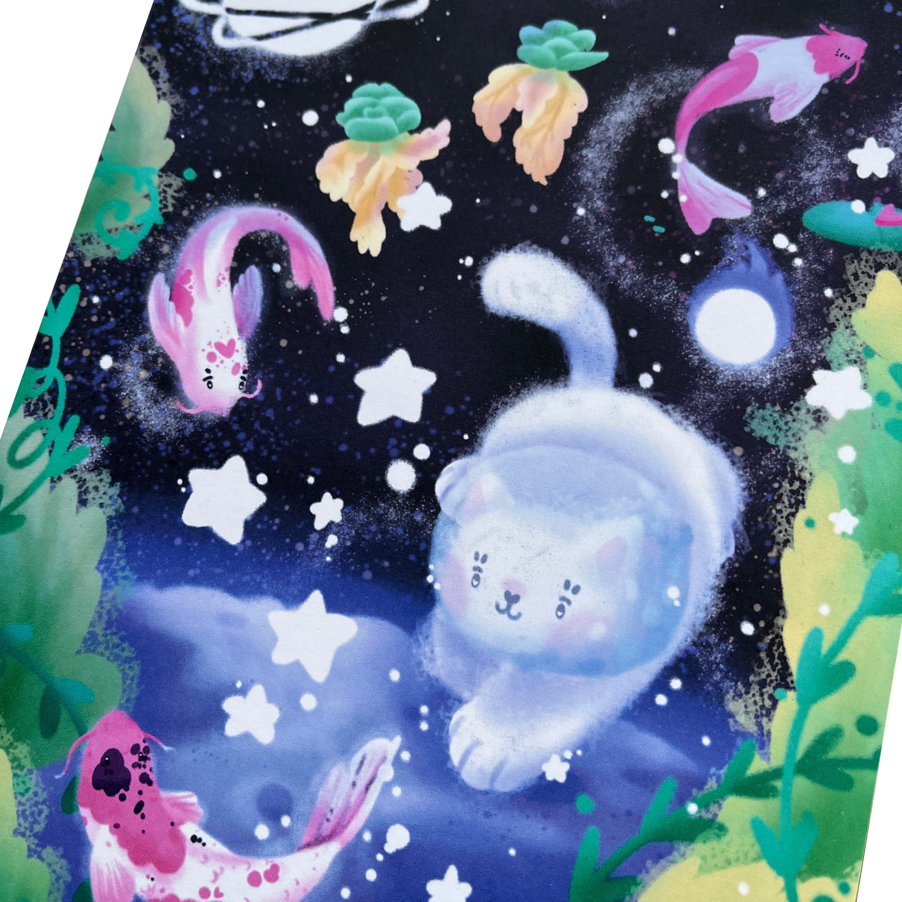 Art print of a white cat with a space helmet, swimming with pink koi fish above the moon.
This print is unframed.