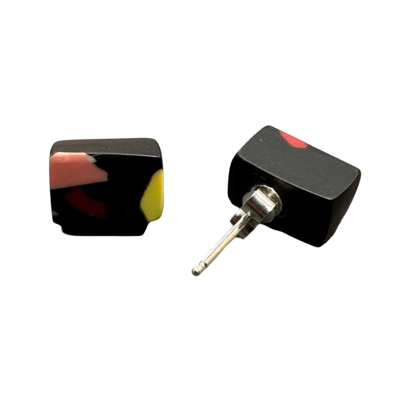 A pair of black cube-shaped stud earrings with colourful resin speckles and silver earring posts.