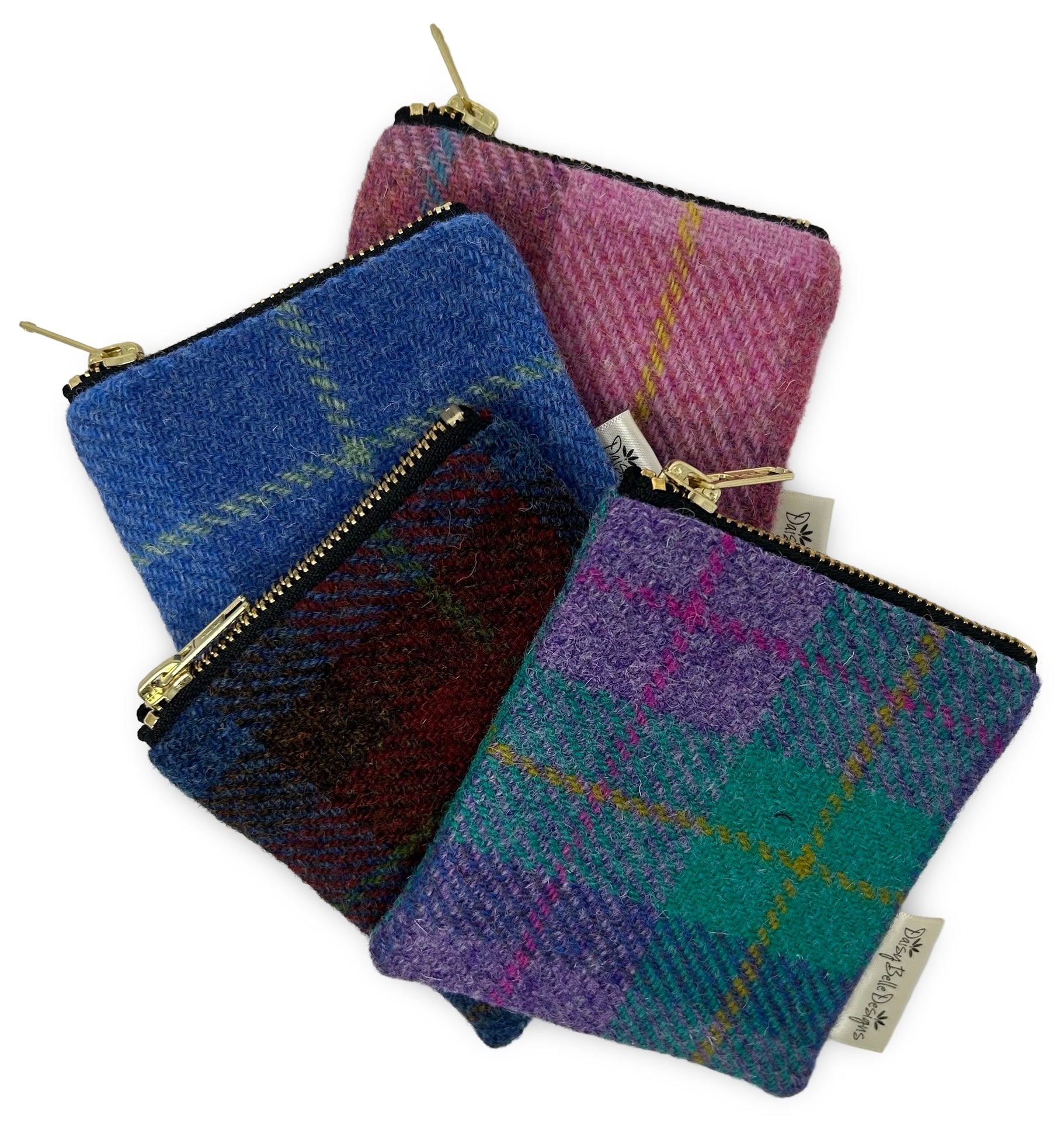Four colours of Harris tweed purses each with a gold zip.