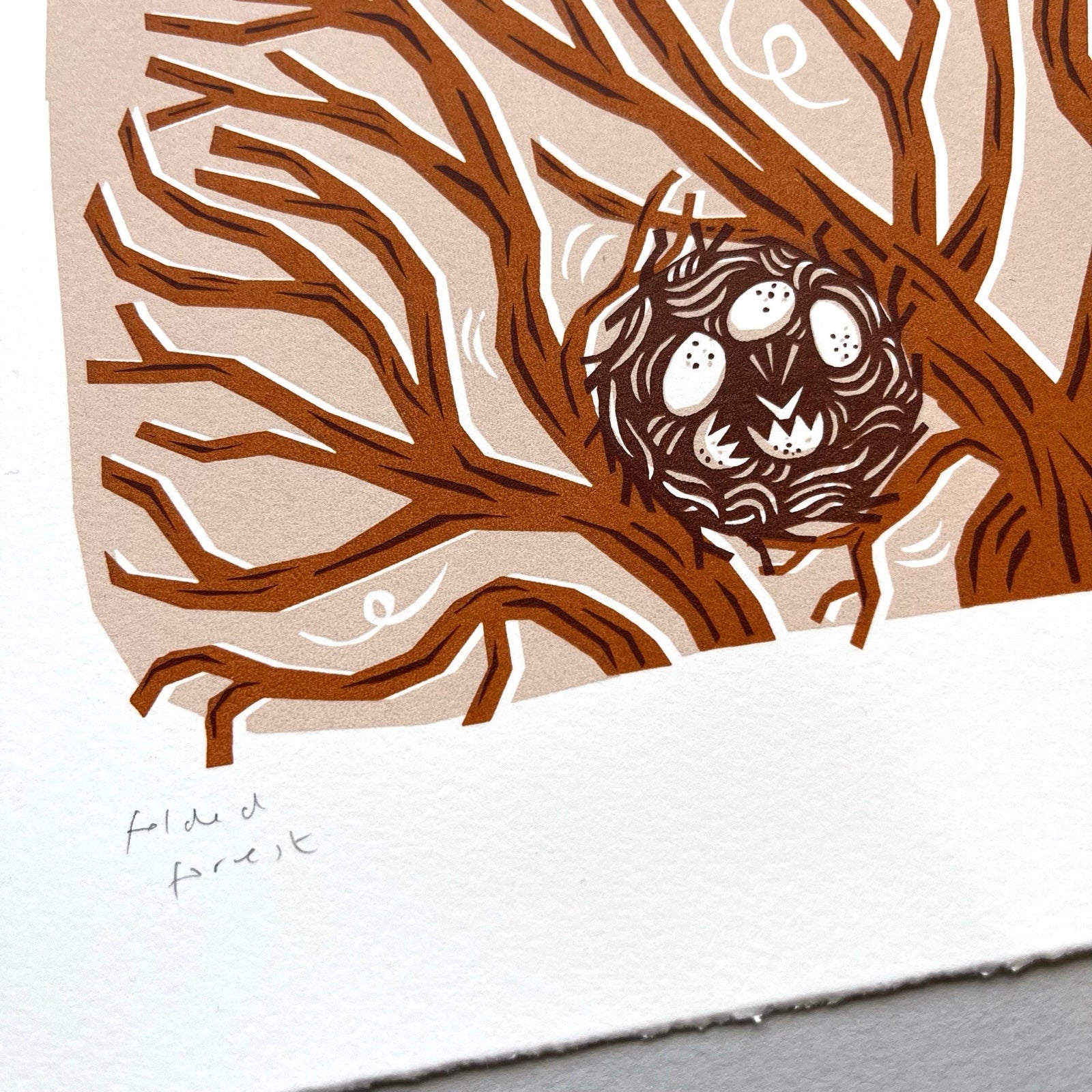 This squirrel screen print is printed in orange, red and peach. It features a squirrel playing in the treetops with a bird's nest resting below, and is printed on hand-torn, thick, satin white paper.