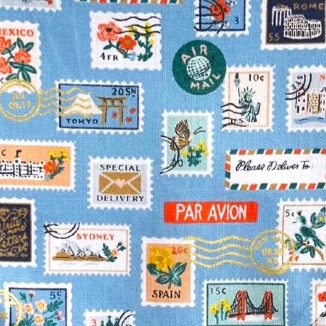 A blue bandana bib for babies with a stamp design, including various stamps.