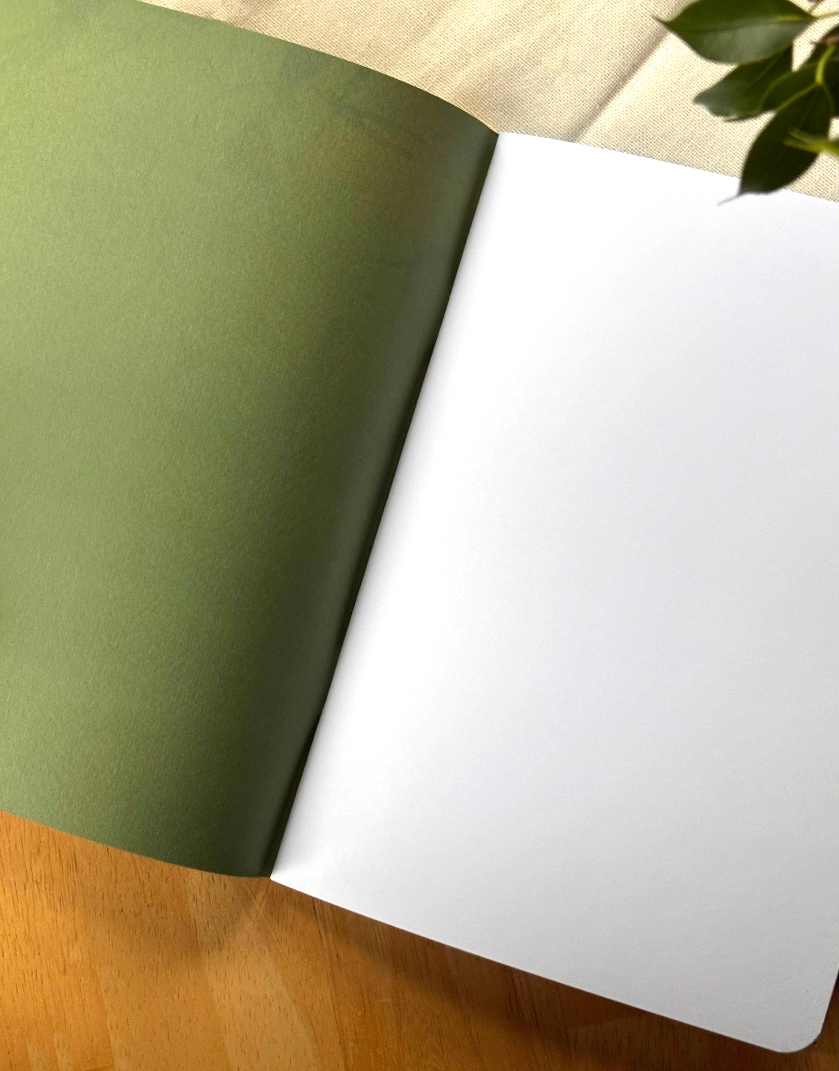 Open book with green and white pages on a wooden surface.