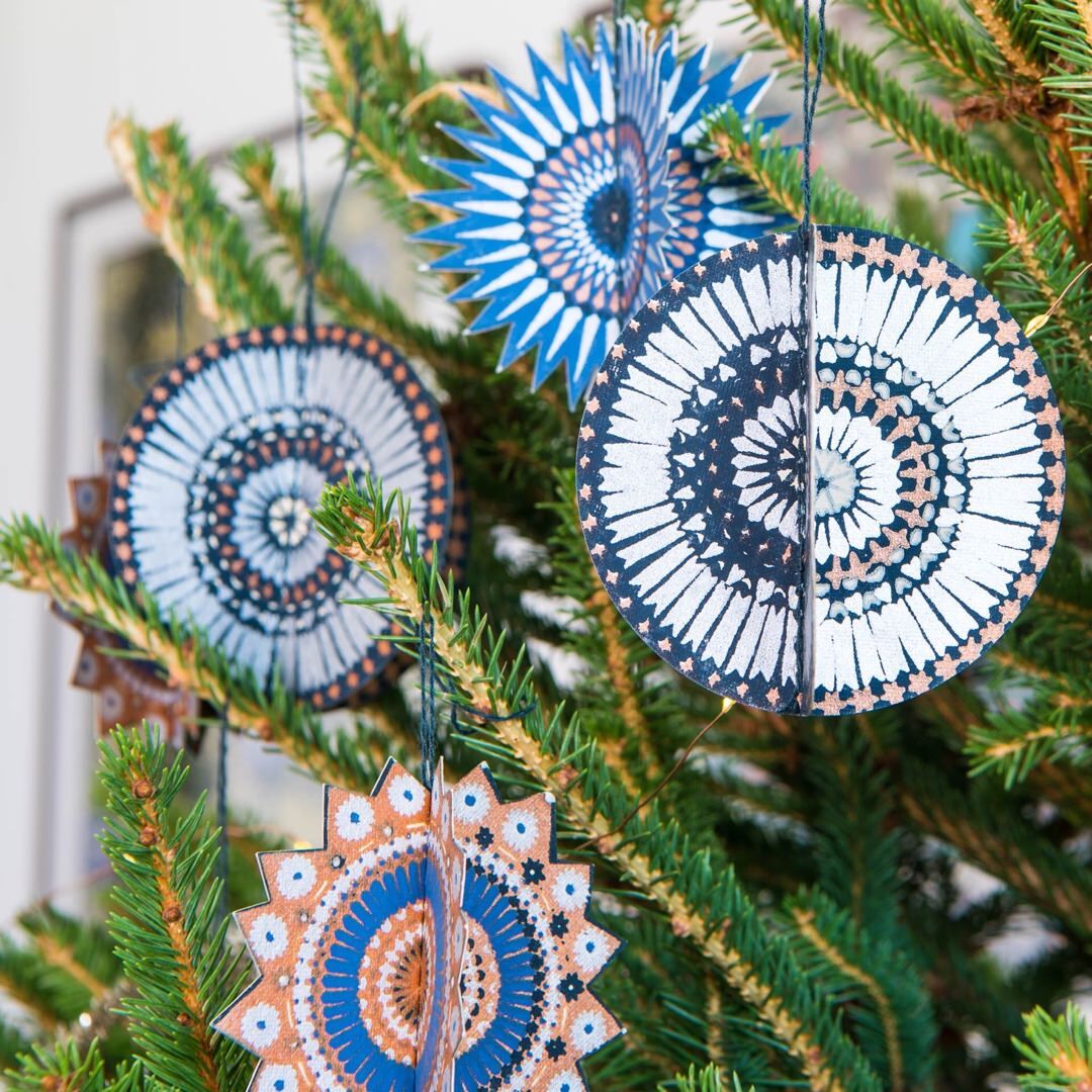 Blue, silver and gold star paper decorations hanging on a Christmas tree