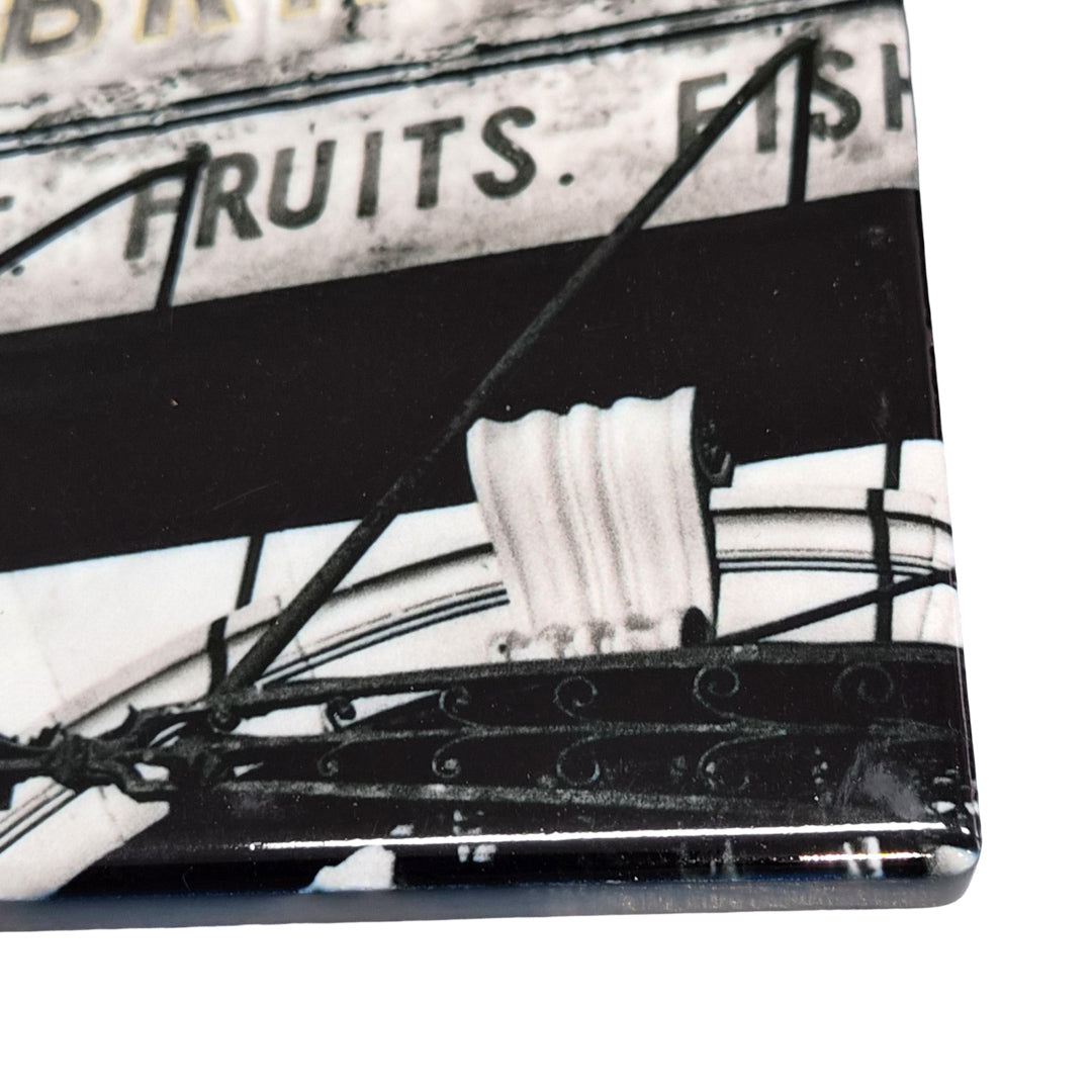 A close up picture of a ceramic coaster featuring a picture of the Stockbridge Edinburgh Market Arch.