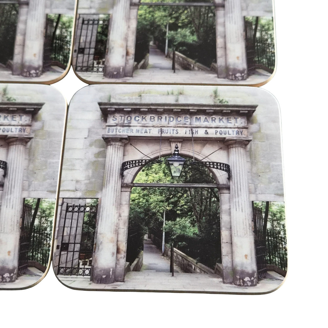 Set of four coasters with aStockbridge Market design featuring columns and an archway.