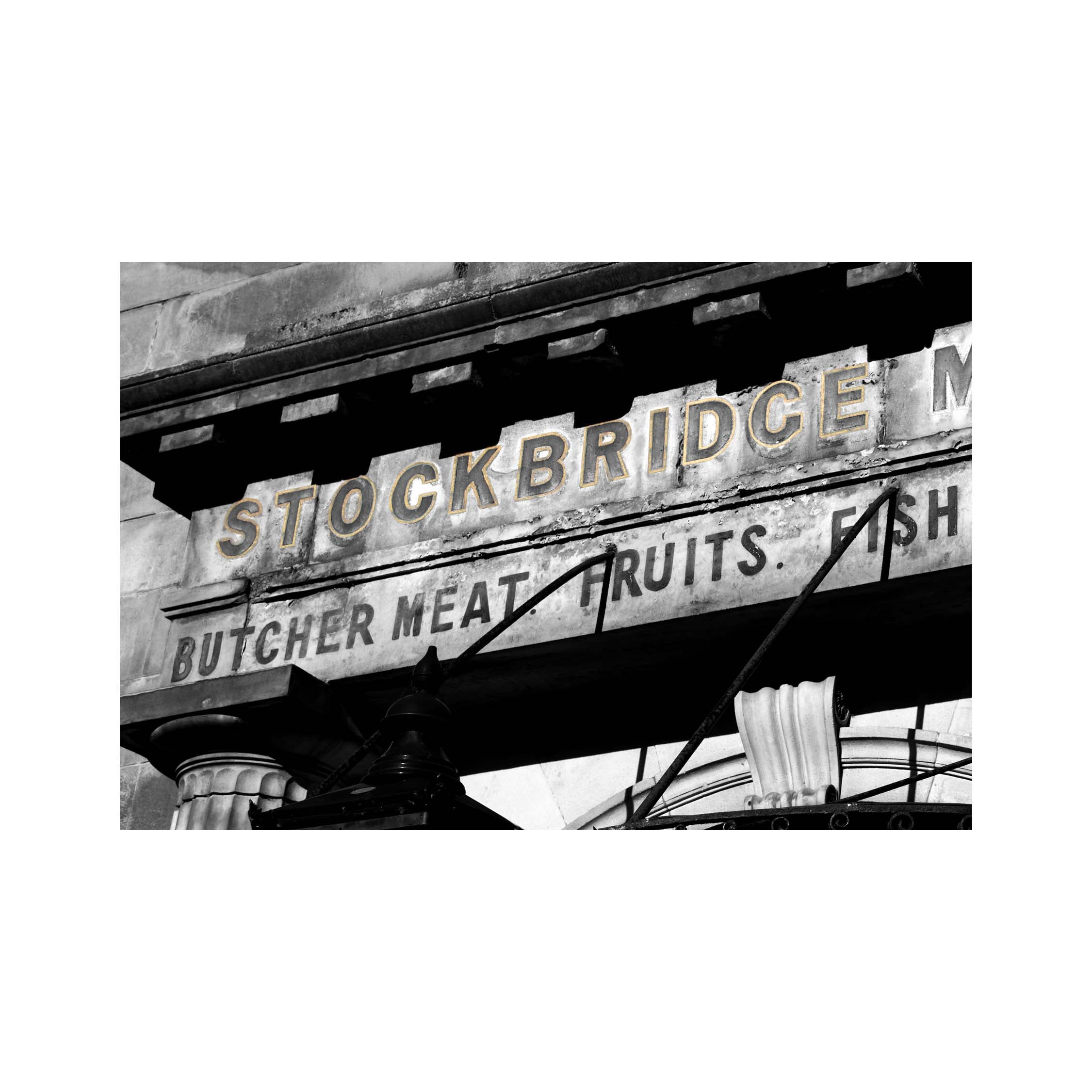 Black and white sign for Stockbridge Market with text 'Butcher Meat Fruits Fish'.