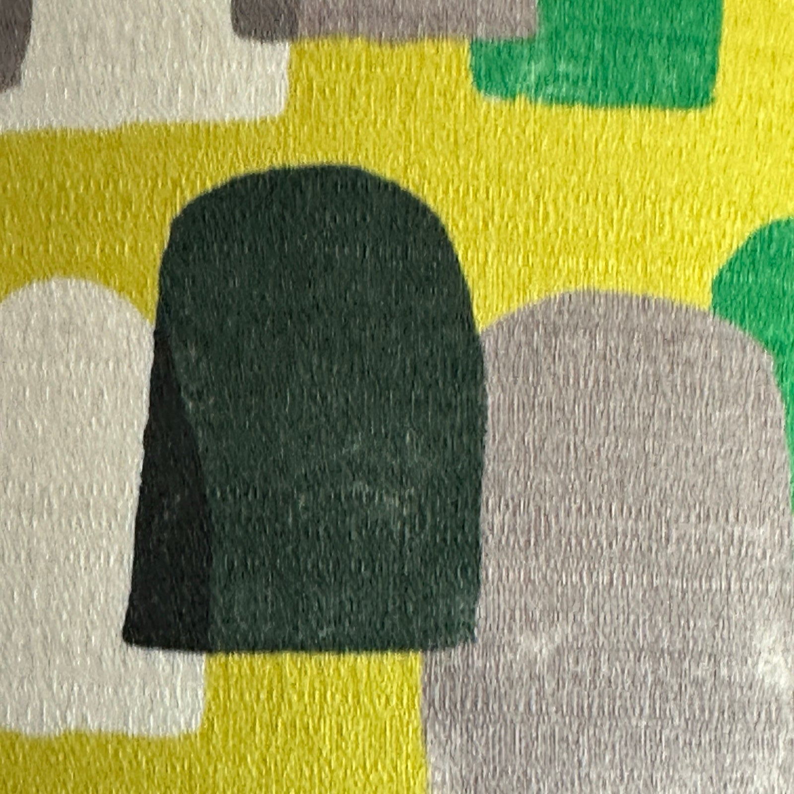 The detail in yellow barkcloth fabric with green, navy, white and brown stones.