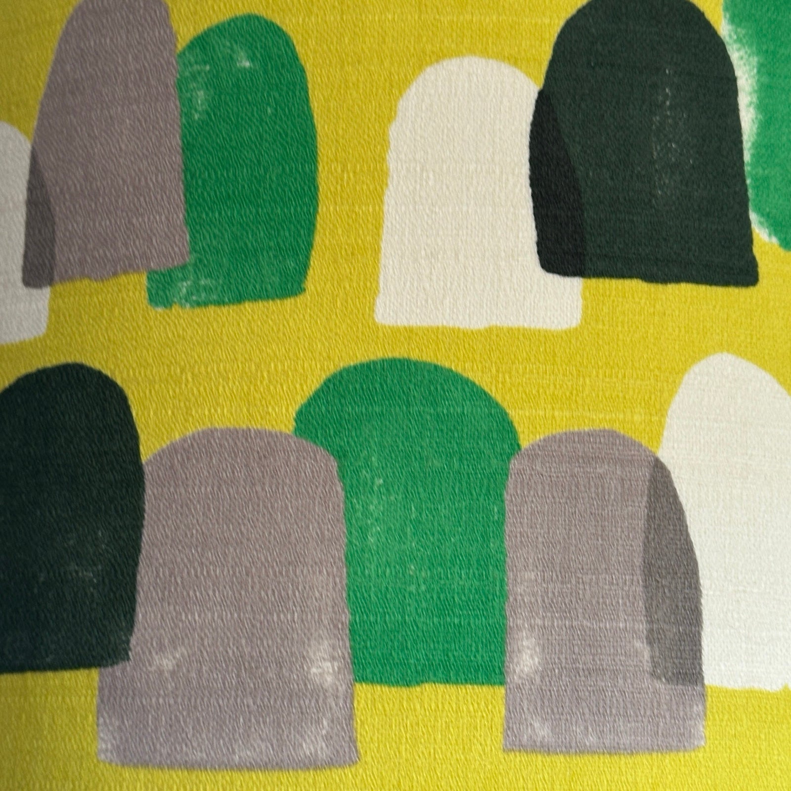 Yellow barkcloth fabric with green, navy, white and brown stones.