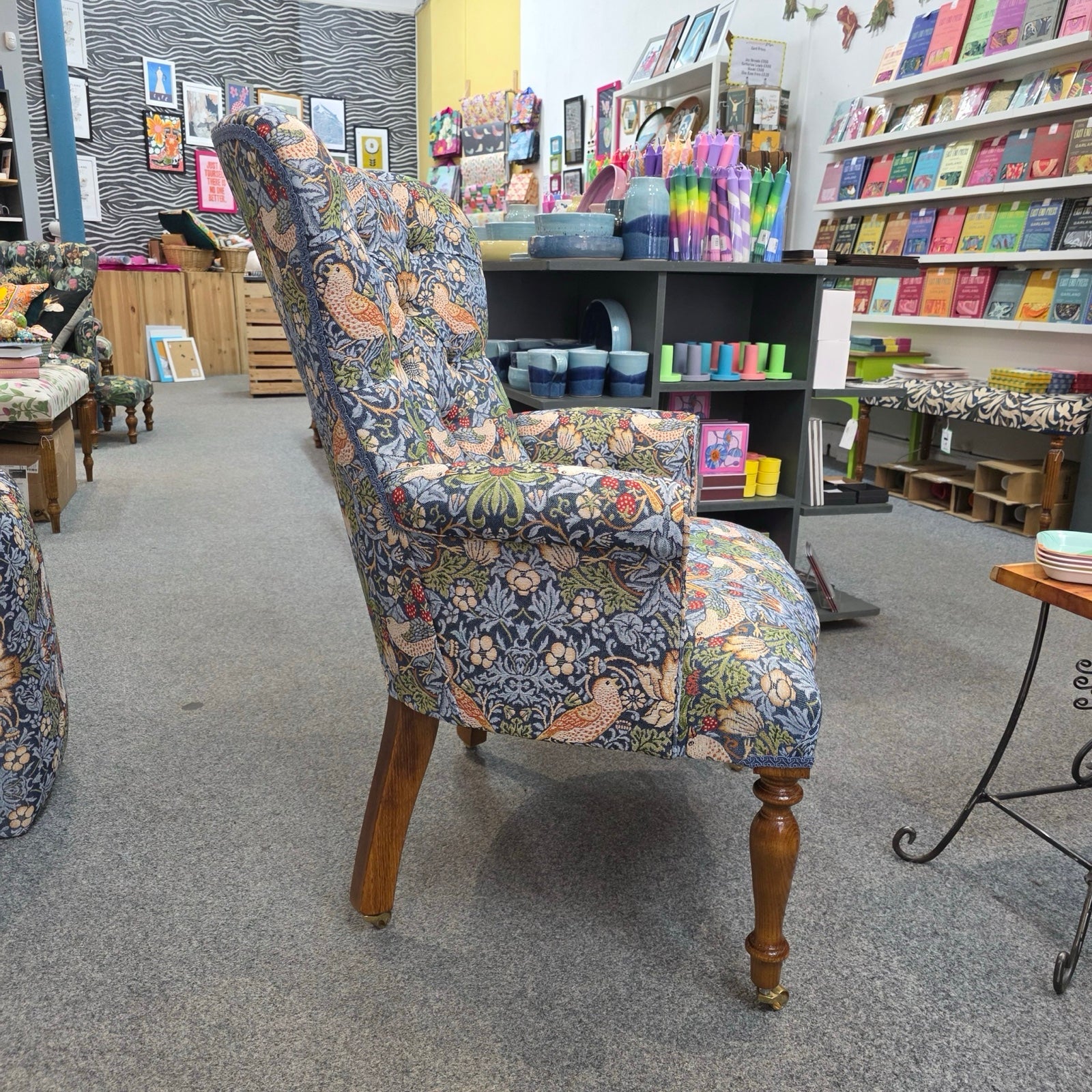 Decorative armchair with floral pattern in a room with shelves.