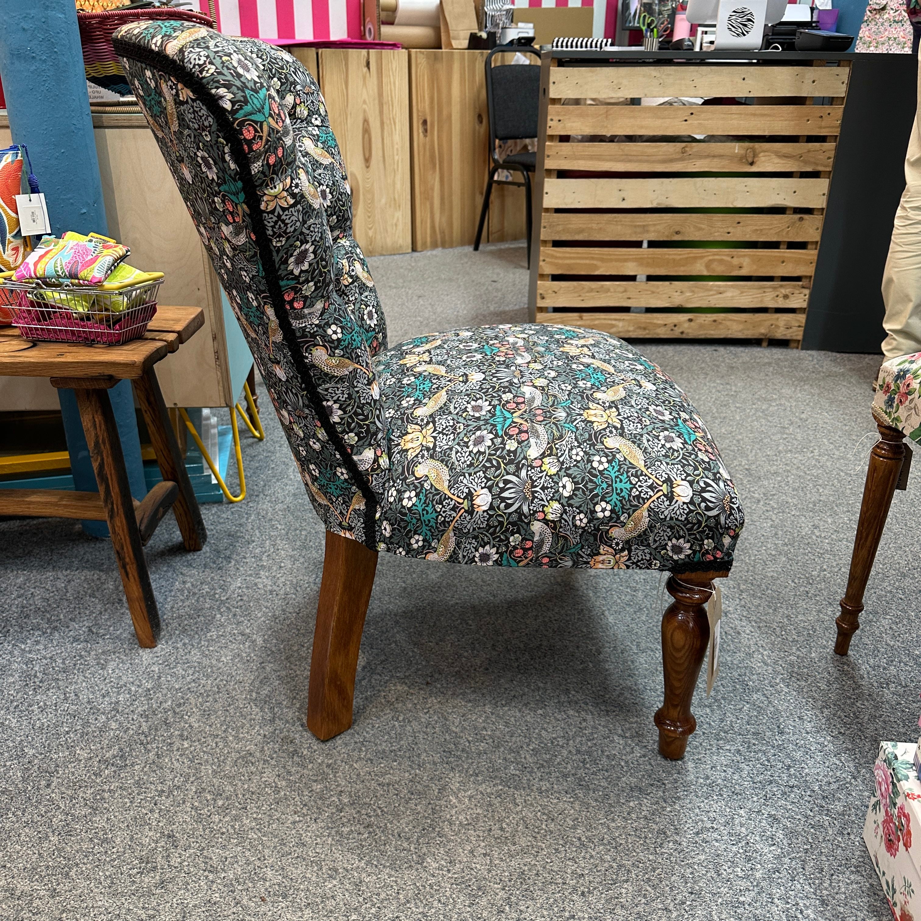 Chair with floral patterned fabric in a room setting.