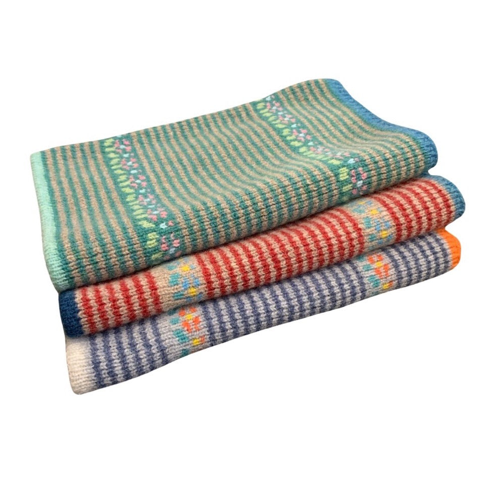 Stack of colourful snoods blankets on a white background.