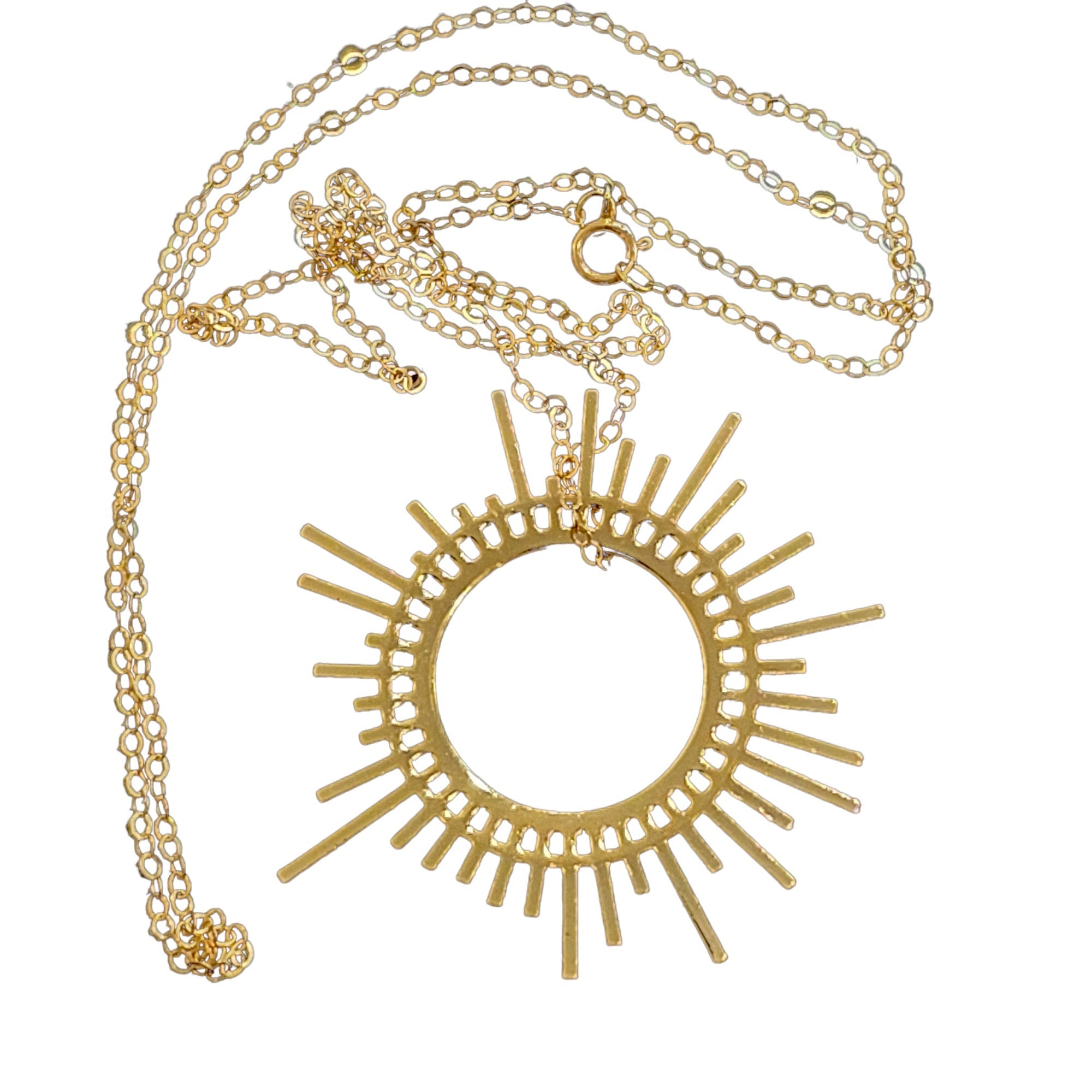 An image of a golden sun shaped necklace against a white background.