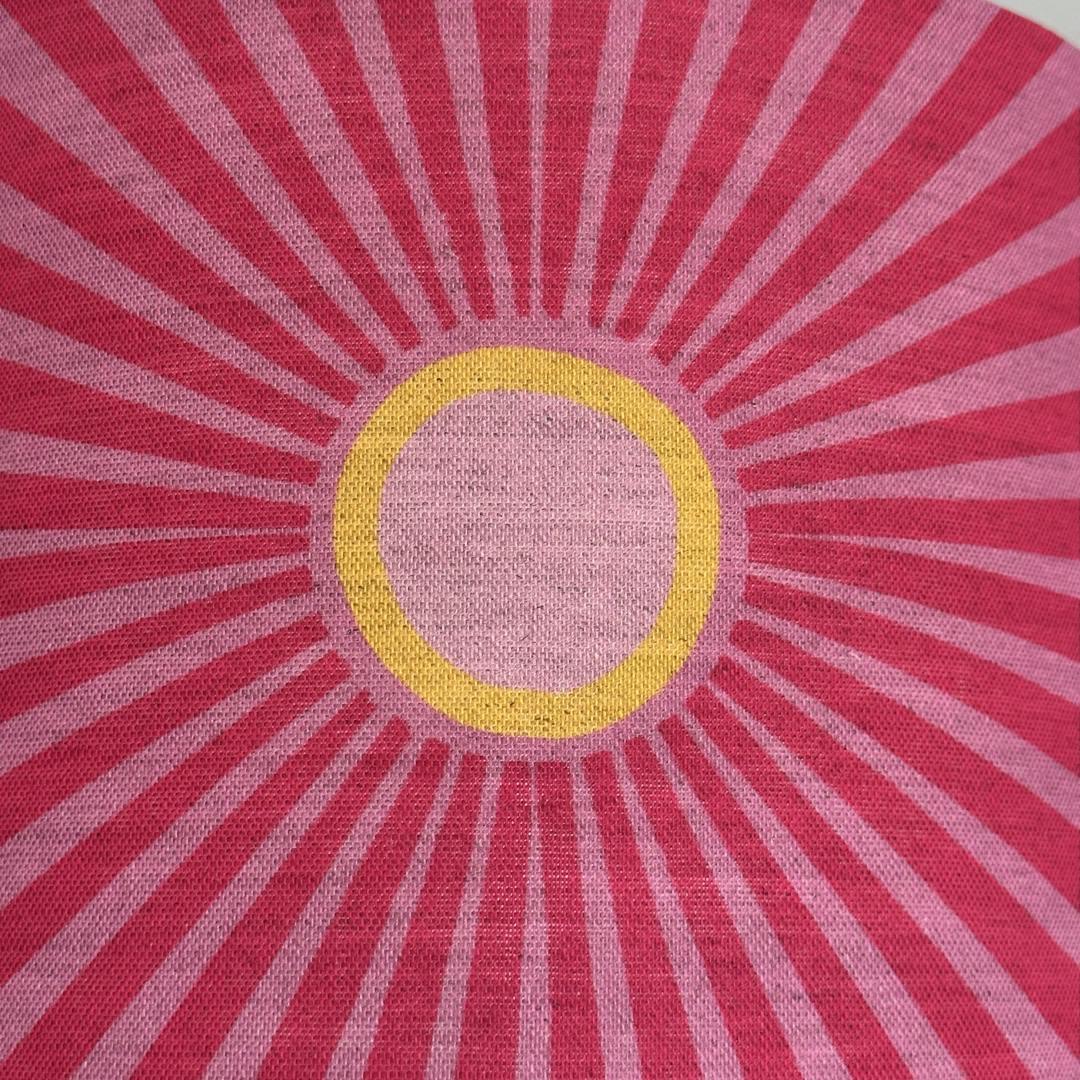 Pink fabric with pale pink and yellow suns and pale pink sunbeams