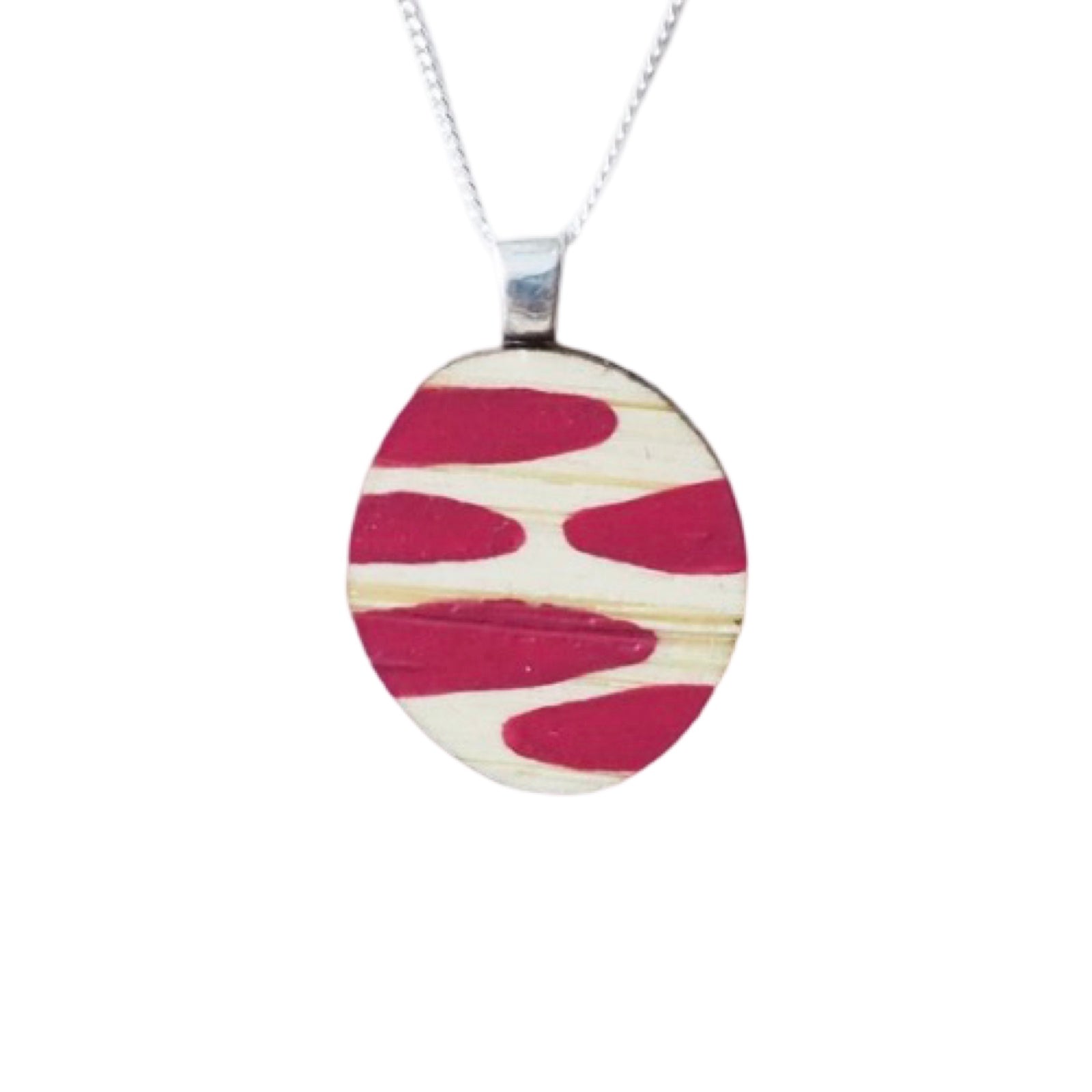 A small wooden necklace with a pink dashed painted pendant and a sterling silver chain.