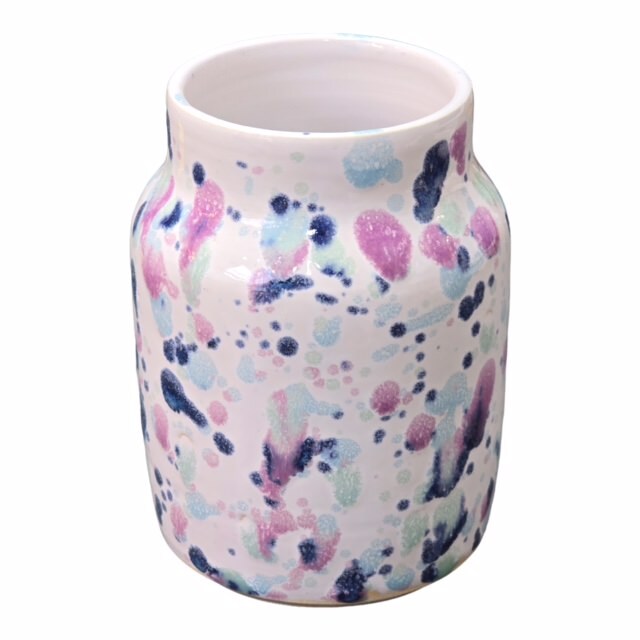 Sweet pea ceramic vase with pink, navy and turquoise shapes against a white background.