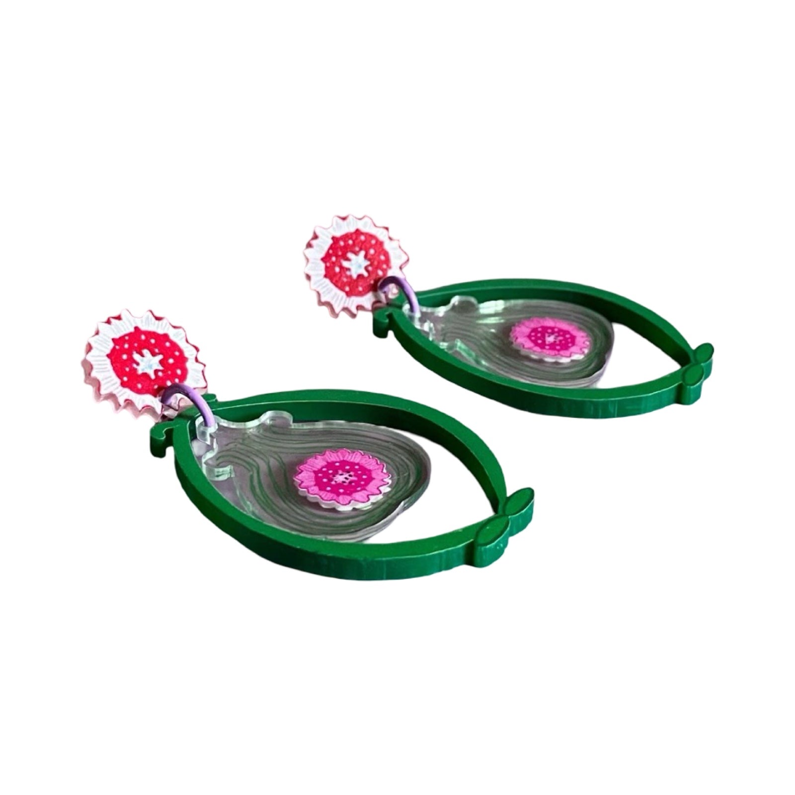 A pair of acrylic earrings with red floral studs and large green ovals with pink flowers inside.