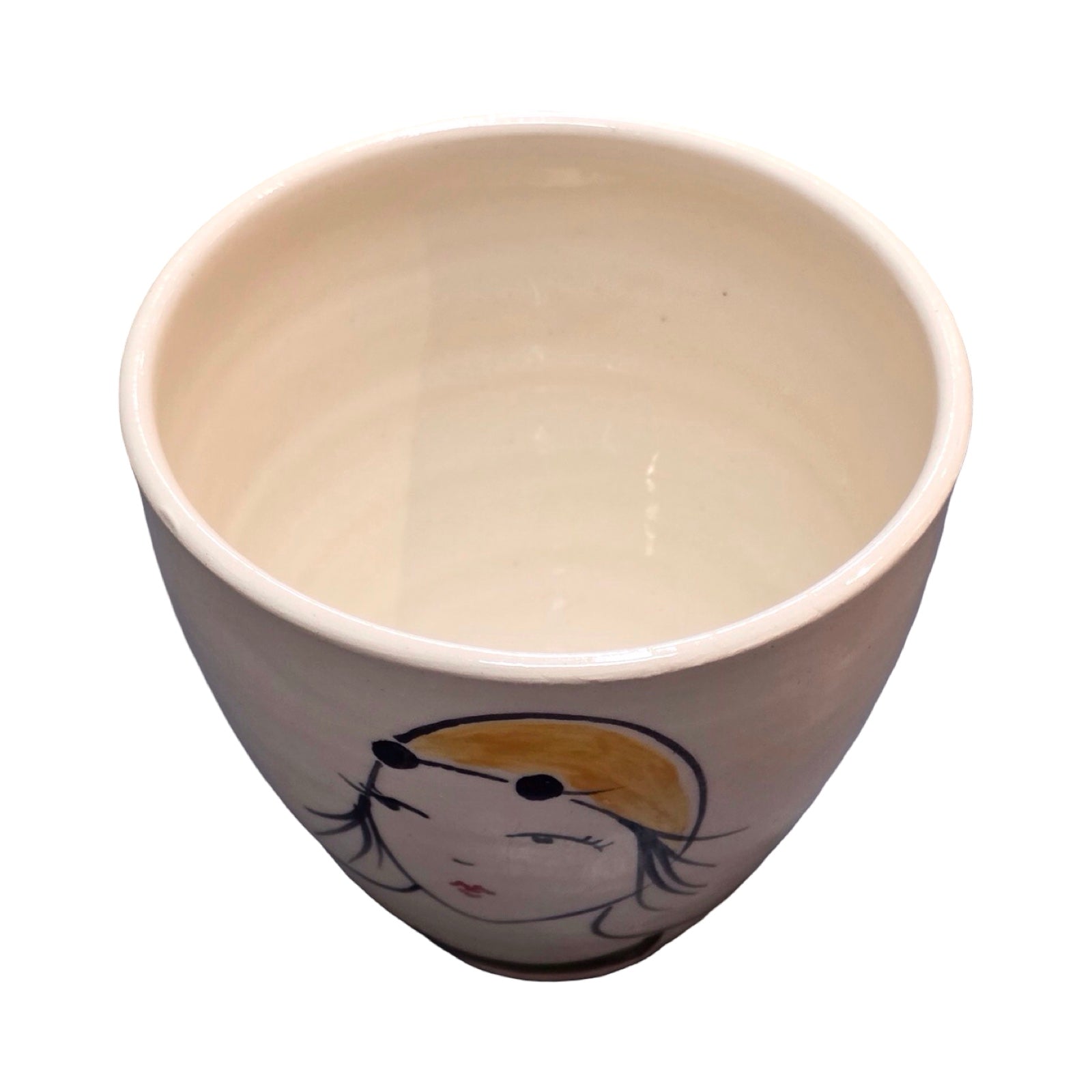 Ceramic cup with a face design on a white background.
