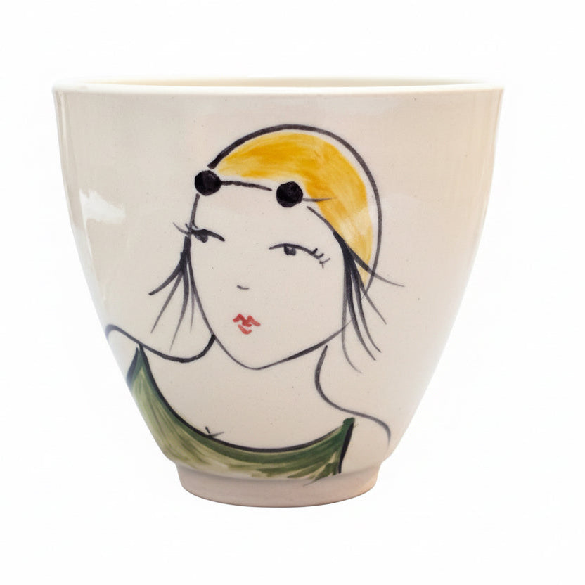 Ceramic cup with a woman's face with a swim cap on a white background.