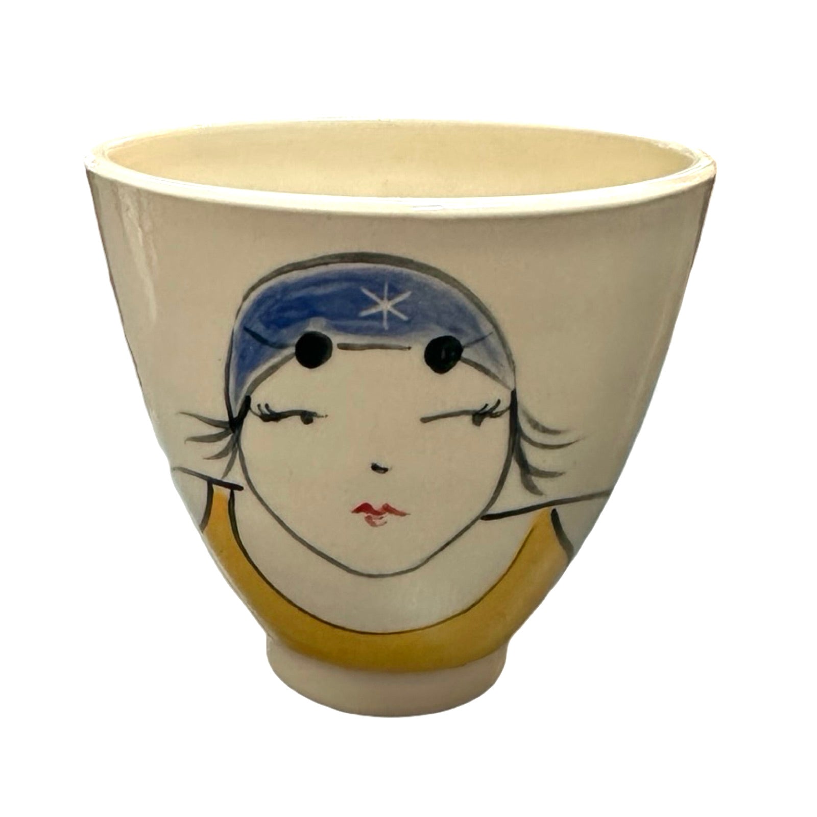 A cream ceramic beaker with a female wild swimmer on the front wearings a yellow swimsuit and a blue swim cap.