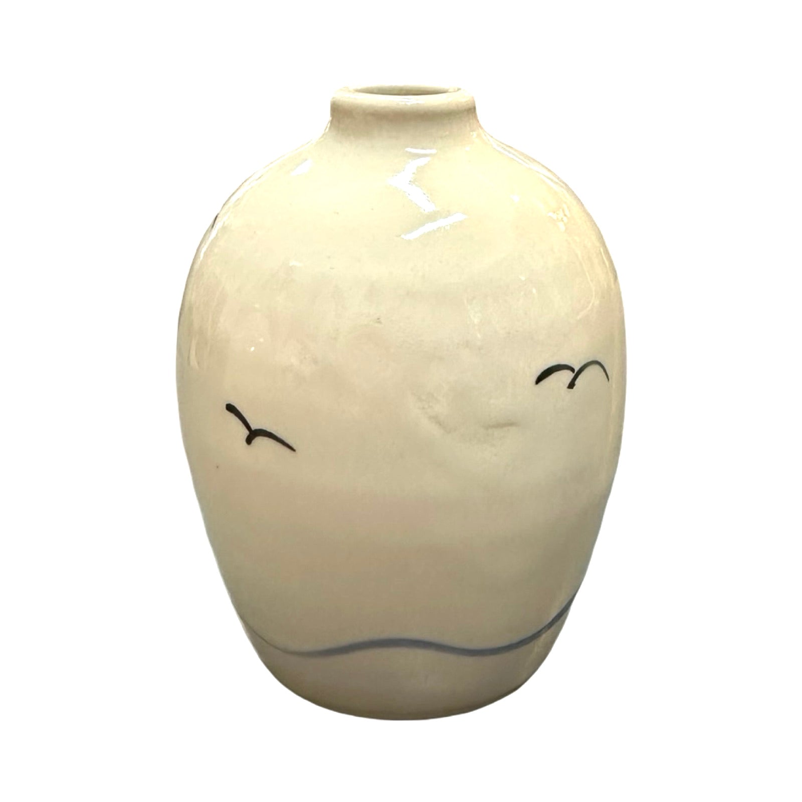 A cream coloured ceramic bud vase with two black flying seagulls and an abstract blue wave along the base.