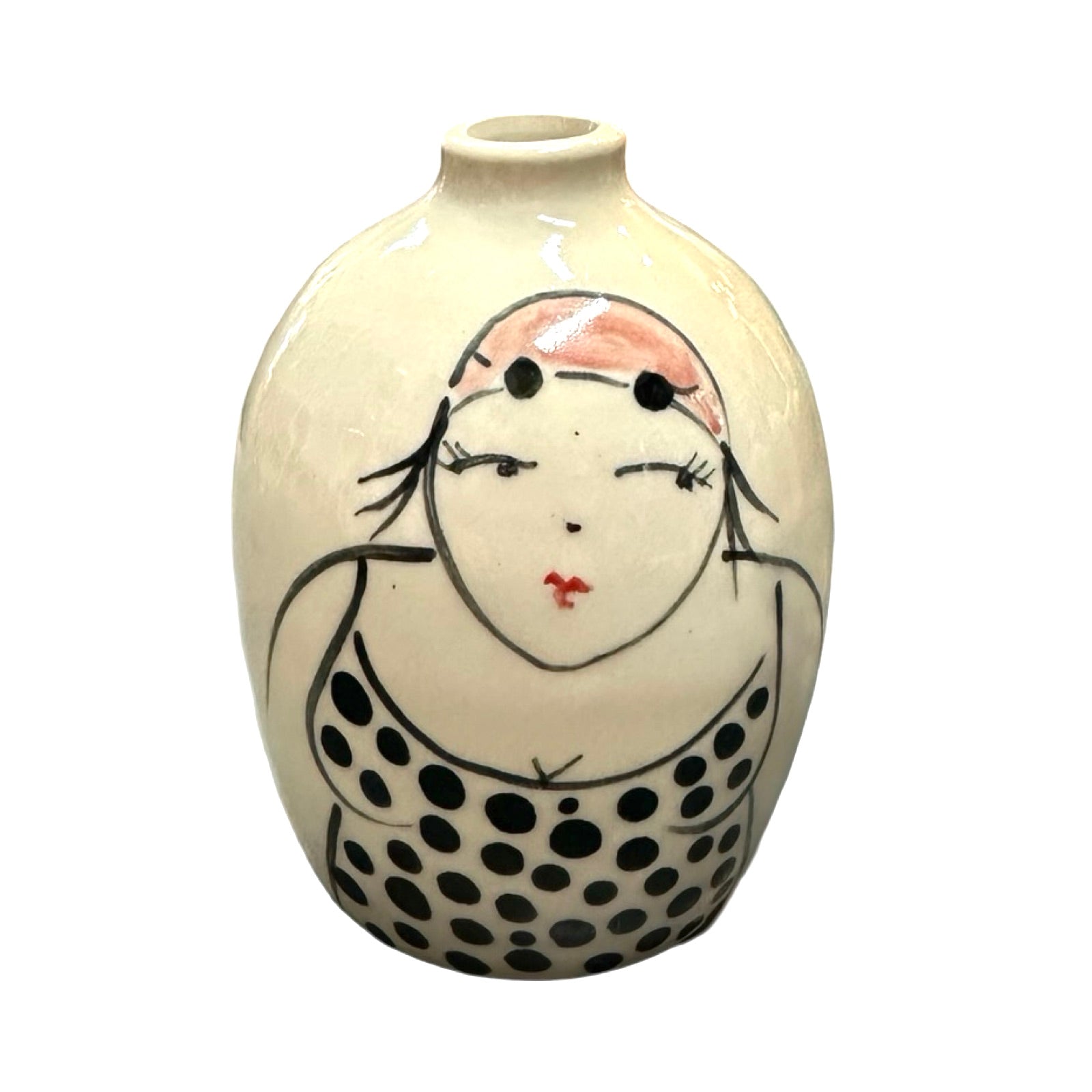 A cream coloured ceramic bud vase with a female wild swimmer wearings a black polka dot swim suit and a pink swim cap.