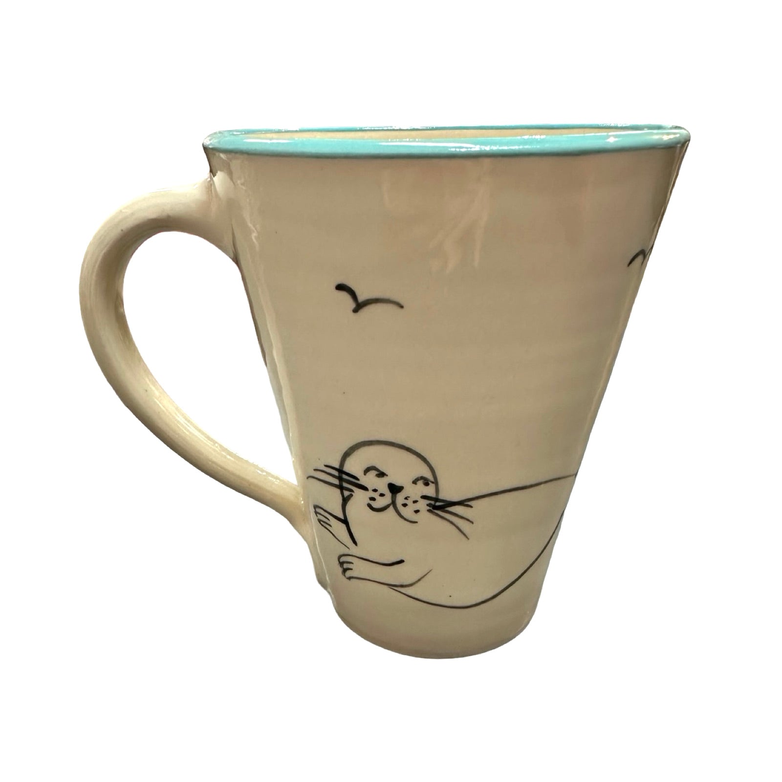 The back of a swimmer mug with a cute seal with a black outline and two black seagulls flying above.