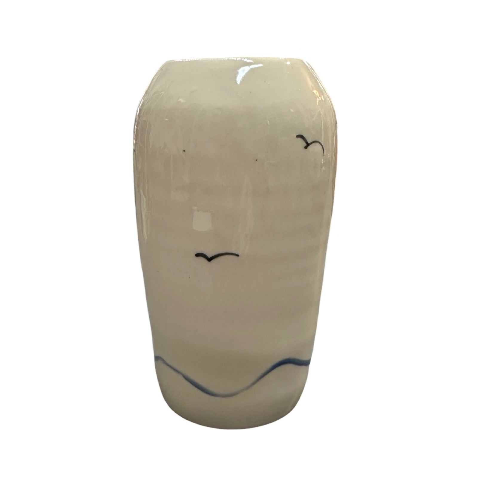 The back of a cylindrical cream ceramic vase with two flying seagulls and an abstract wave design at the base.