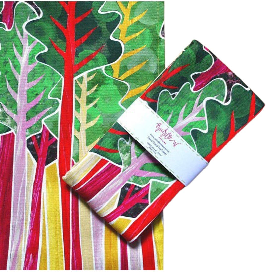 Folded tea towel featuring purple, pink and yellow Swiss chard with green leaves on a yellow background.