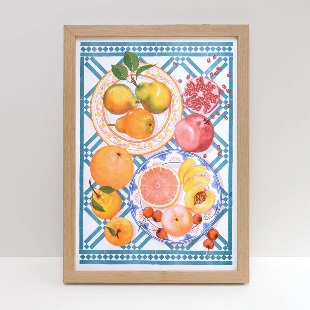 Framed artwork of fruits on a decorative background.