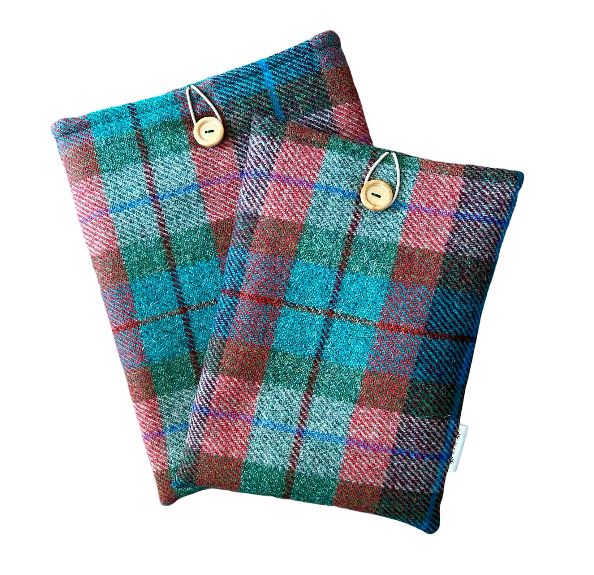 Two sizes of Harris tweed tablet sleeves in red and green tartan check. Bothe sleeves have an elastic loop and wooden button at the top.