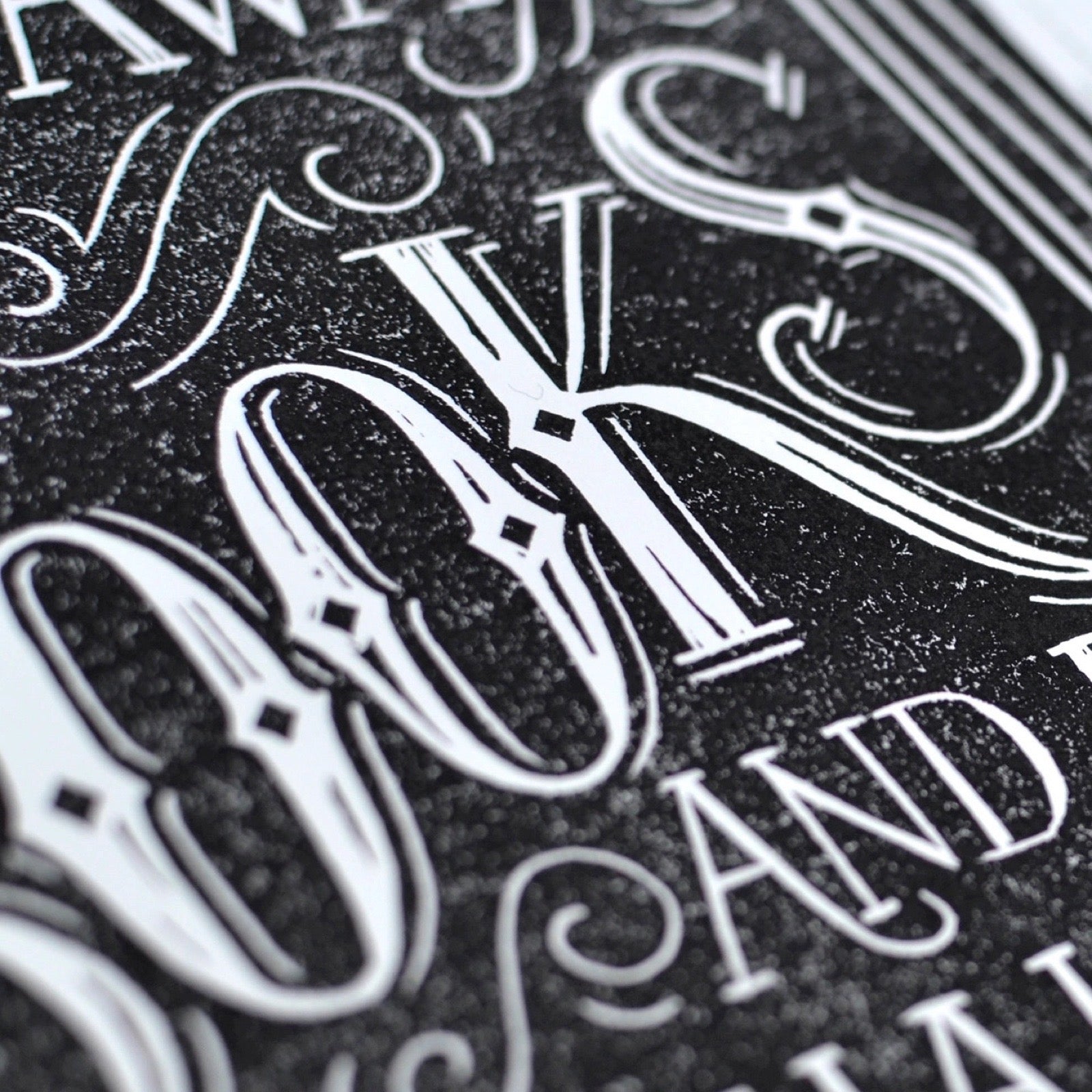 Close-up of ornate white text on a black textured background.