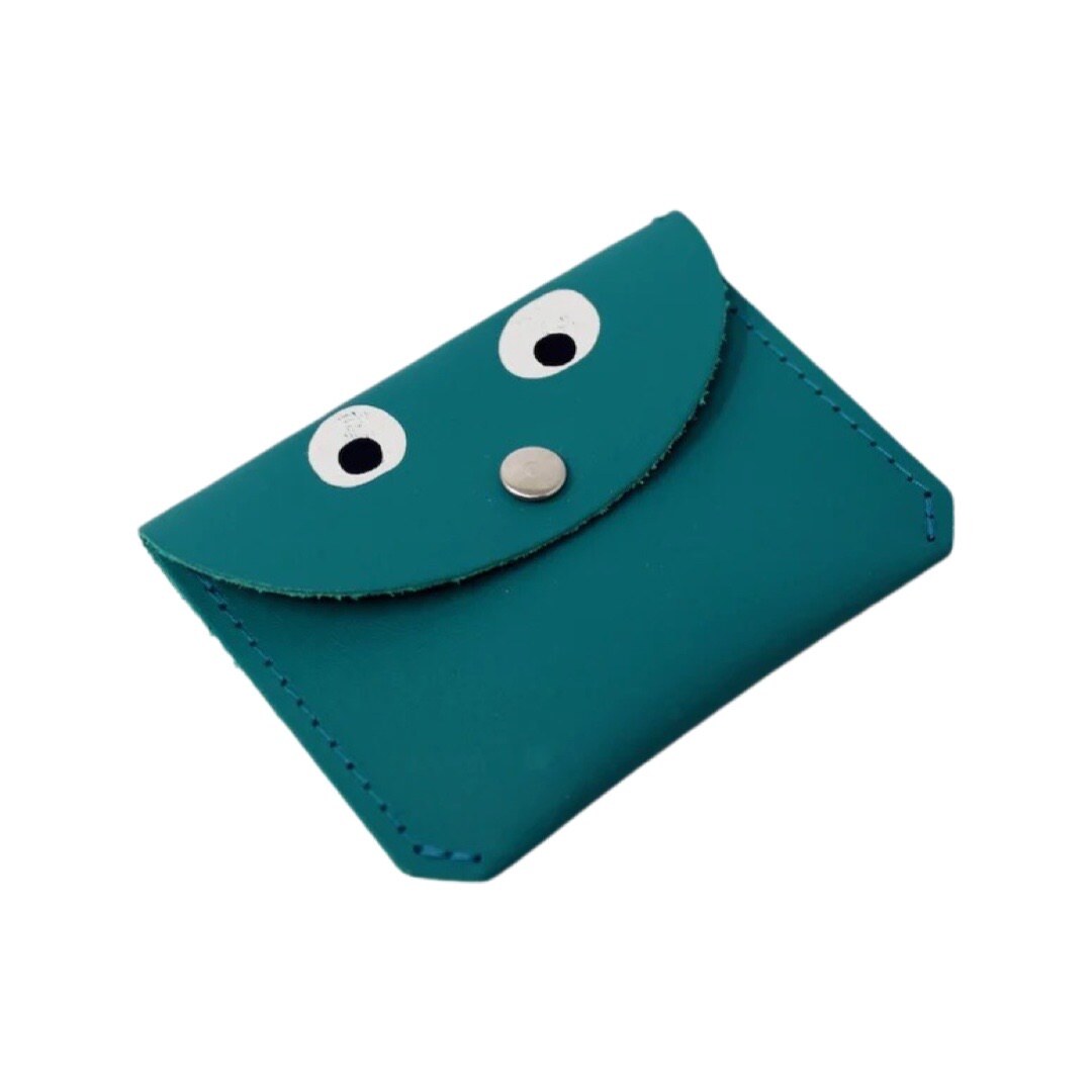 A teal leather coin purse with googly eyes and a gold fastening in the centre.