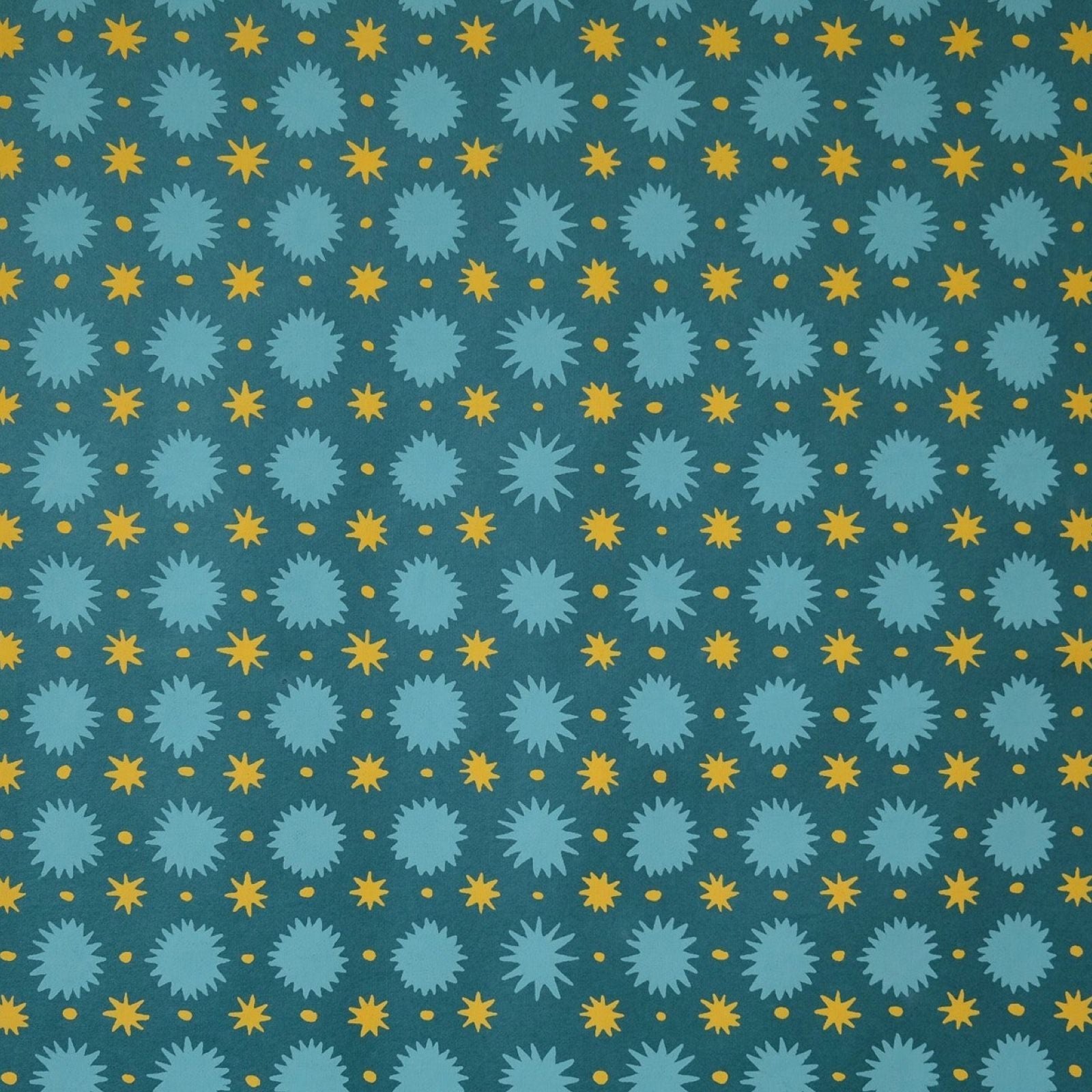 Screen-printed wrapping paper with turquoise and yellow stars against a teal background.
