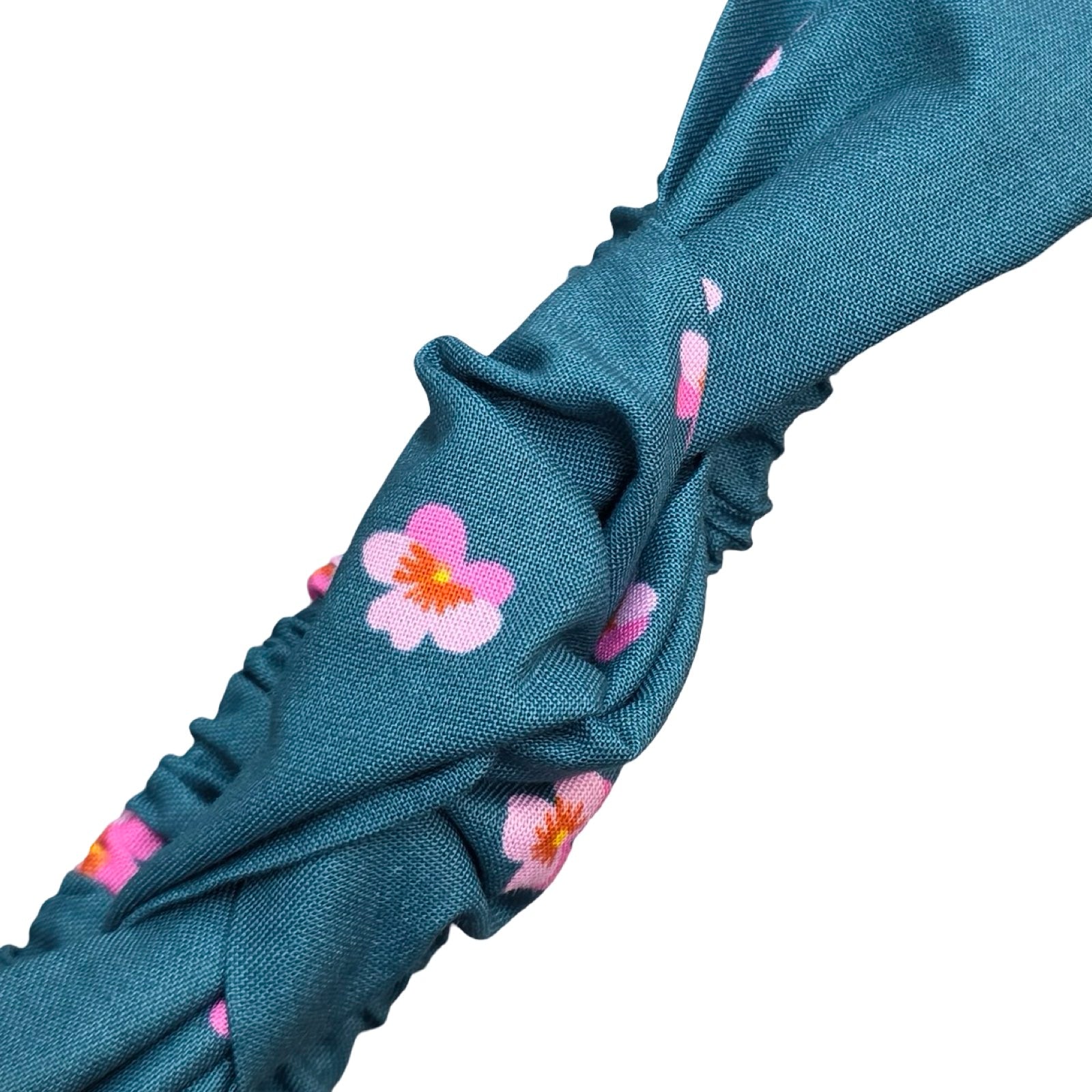 This handmade teal floral knotted headband is made from 100% cotton fabric with pink violets.
