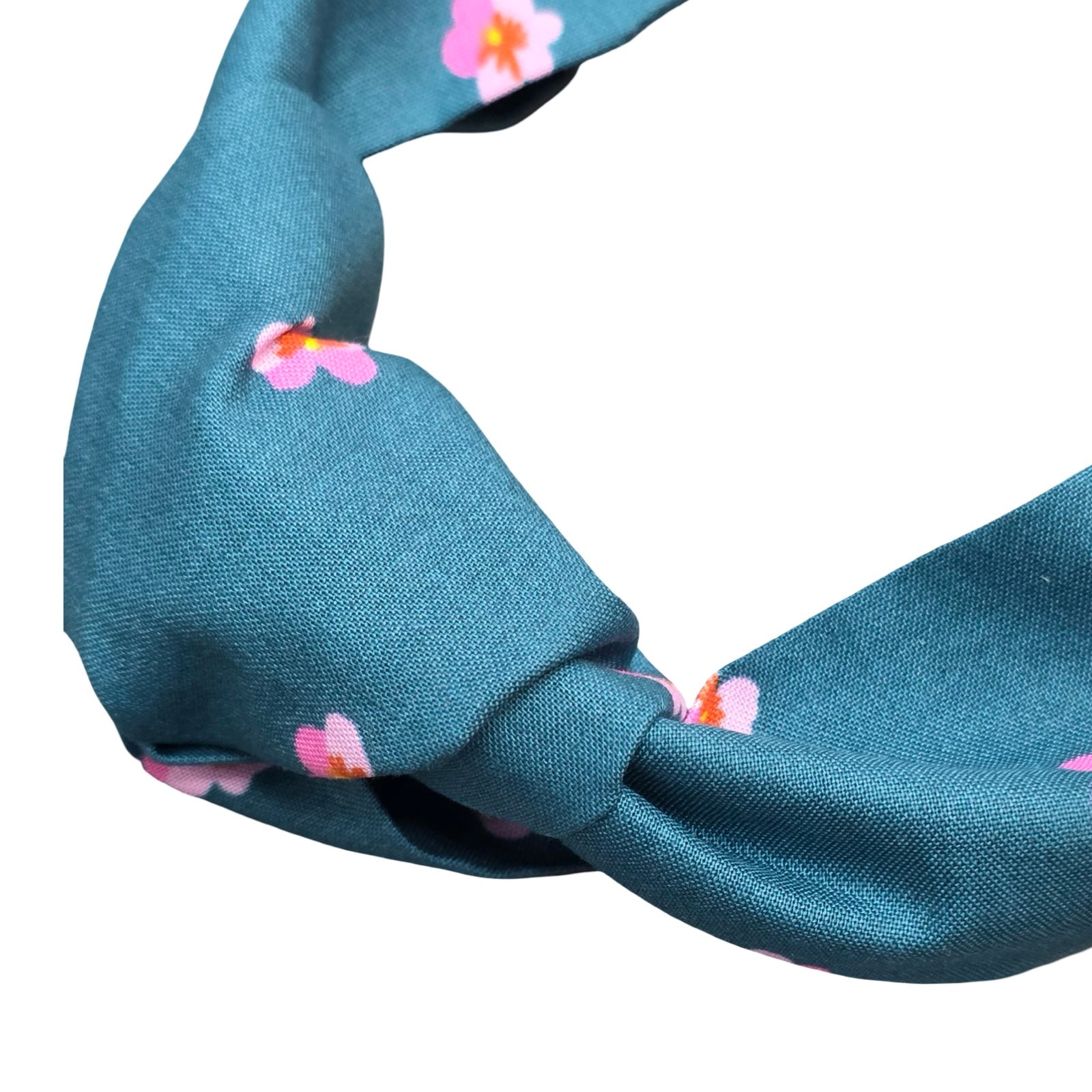 This teal handmade floral top-knot Alice band is made from 100% cotton fabric with small pink violets.