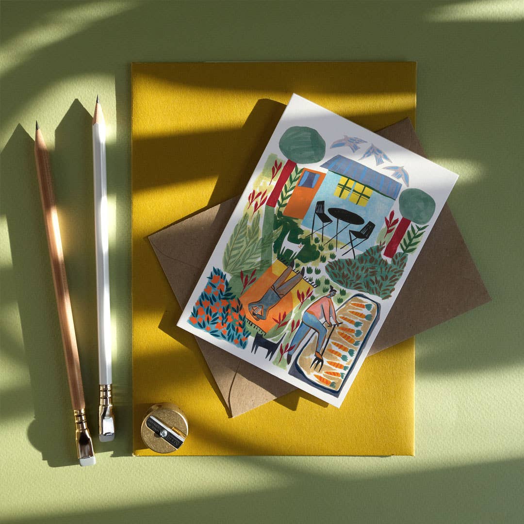Greeting card with outdoor scene design on a yellow envelope with stationery items.