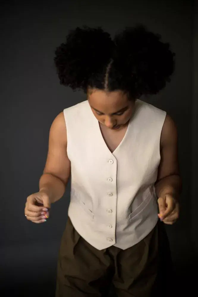 Sewing pattern for a waistcoat with a structured, boxy fit, two welt pockets and a simple stitched belt at the back.
