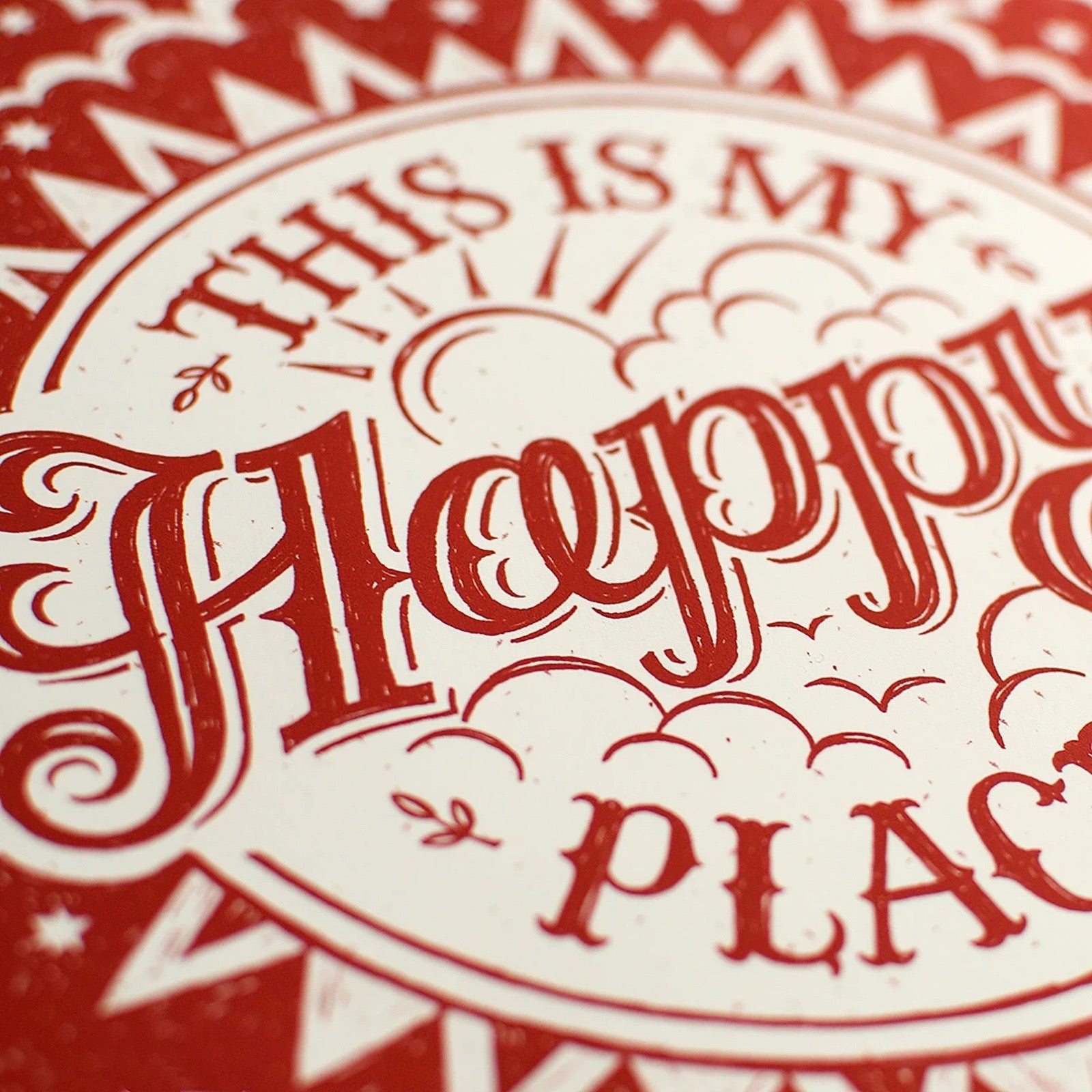 Decorative print with text saying 'This is my happy place' on a red and beige background.